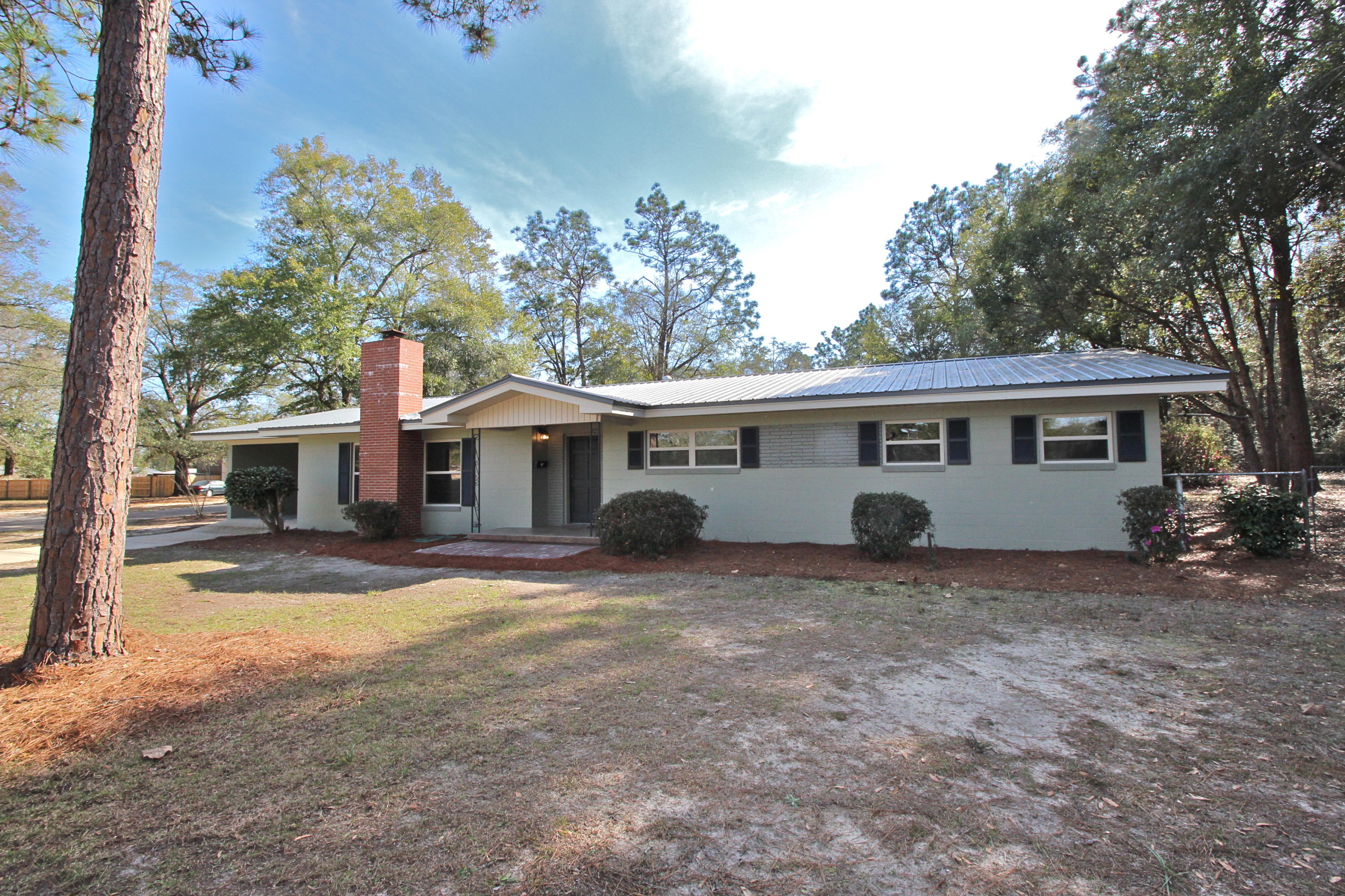 Price reduced and move in ready! Located in the city in a great neighborhood with no HOA. This classic, solid brick and block home on 3/4 acre has plenty of updated features with hints of vintage (in super condition)! All new vinyl windows & doors, new laminate floors, new paint inside & out, metal roof and freshly updated kitchen with granite & new appliances. Solid pine walls give it that cottage character you can't duplicate (some natural, some painted). Huge family room has wood stove and separate dining/den. Master bedroom has a walk-in closet and a dressing/sitting area too! The all new full bath shines with tub/shower combo and granite countertop. Covered front and back porches, 1/2 bath in the garage and fenced back yard.