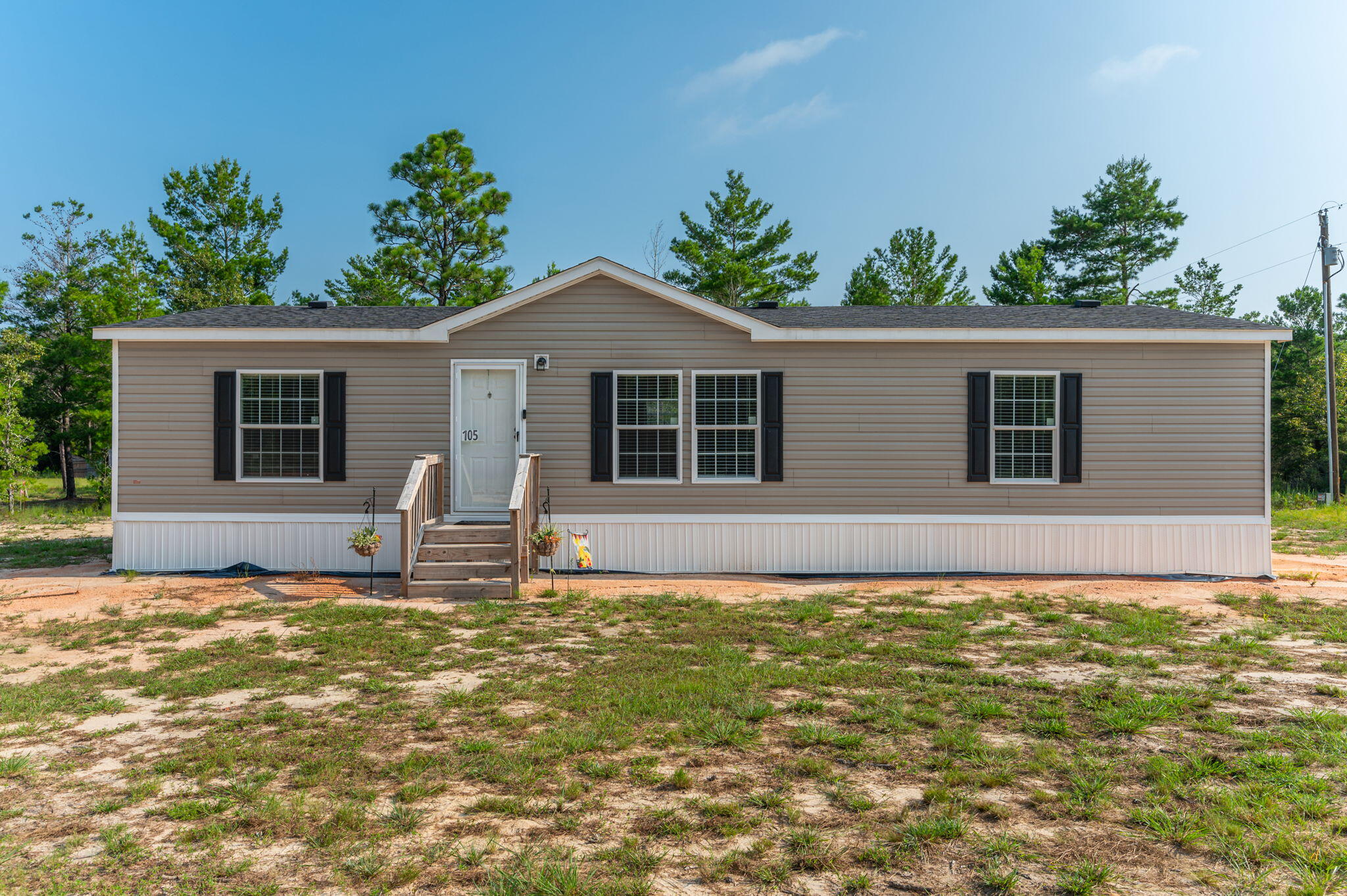 This 2022 manufactured home sits on a .23-acre lot and offers 1,352 sq ft of comfortable living space. It features 3 bedrooms, 2 baths, and a split floor plan. The home is equipped with central air conditioning and heating. The kitchen includes matching appliances and a breakfast bar. Carpeted living area and bedrooms, with vinyl flooring in wet areas. The ensuite boasts a separate walk-in shower and a large tub. Each bedroom has a spacious closet, providing ample storage. This home is priced to move. Don't miss the opportunity to make it yours.