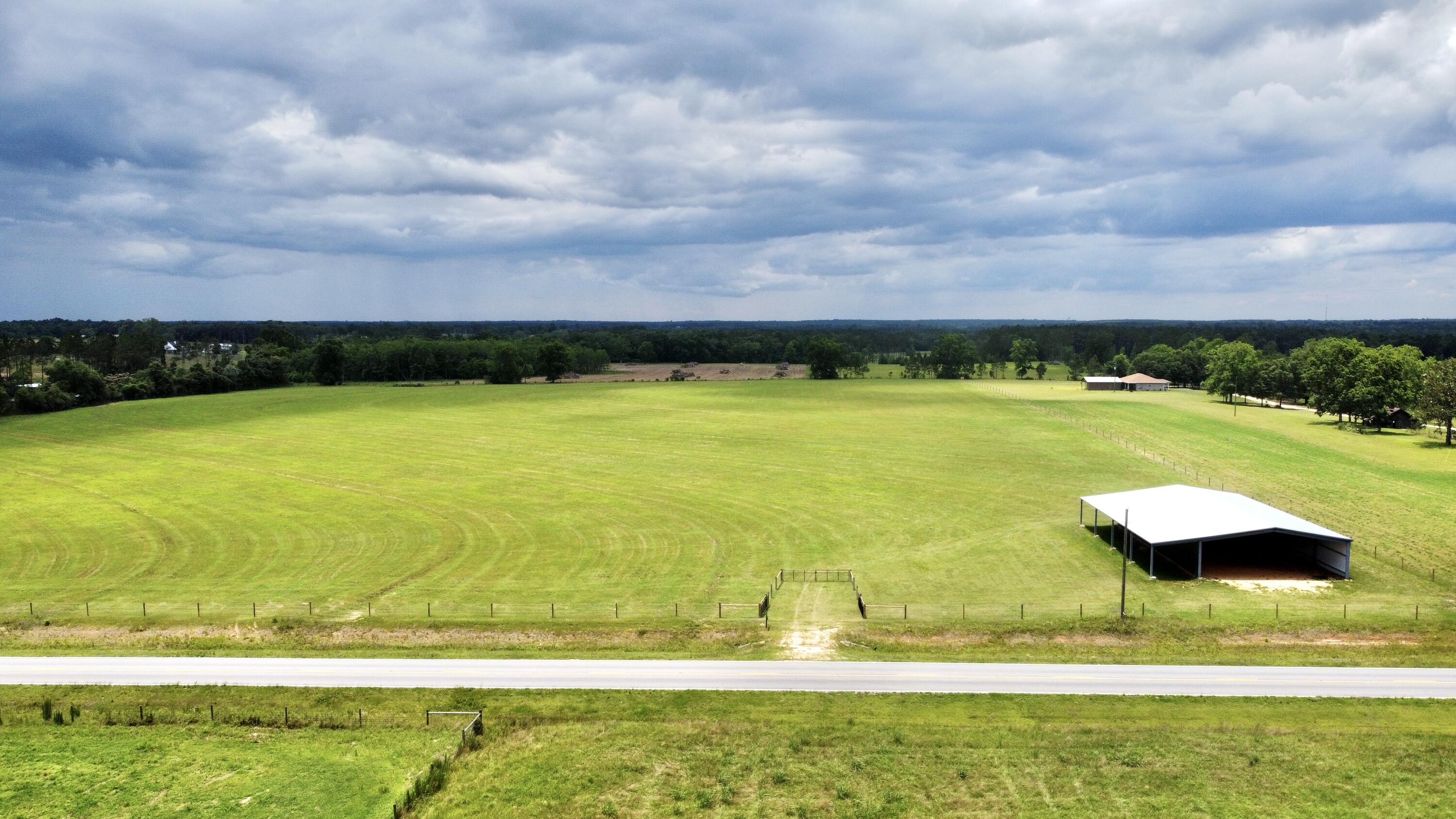 This Beautiful property consist of 28.57 acres +- with a 50'x100' all steel constructed barn with an additional 16'x100' wing down one side. Seller has invested over $20,000.00 in fencing, water tap, and power!! The hay field has been sprigged in Tifton 85 Bahia and has been fertilized before each cutting as well as being limed each year. This amazing property is high and dry and is just a short drive to the beach allowing for easy access to the emerald waters of Northwest Florida. Power is available along the properties edge. With highway frontage along the entire front of the property, this would allow for easy access whether you're farming or building your dream home! Bring your horses and house plans!!!