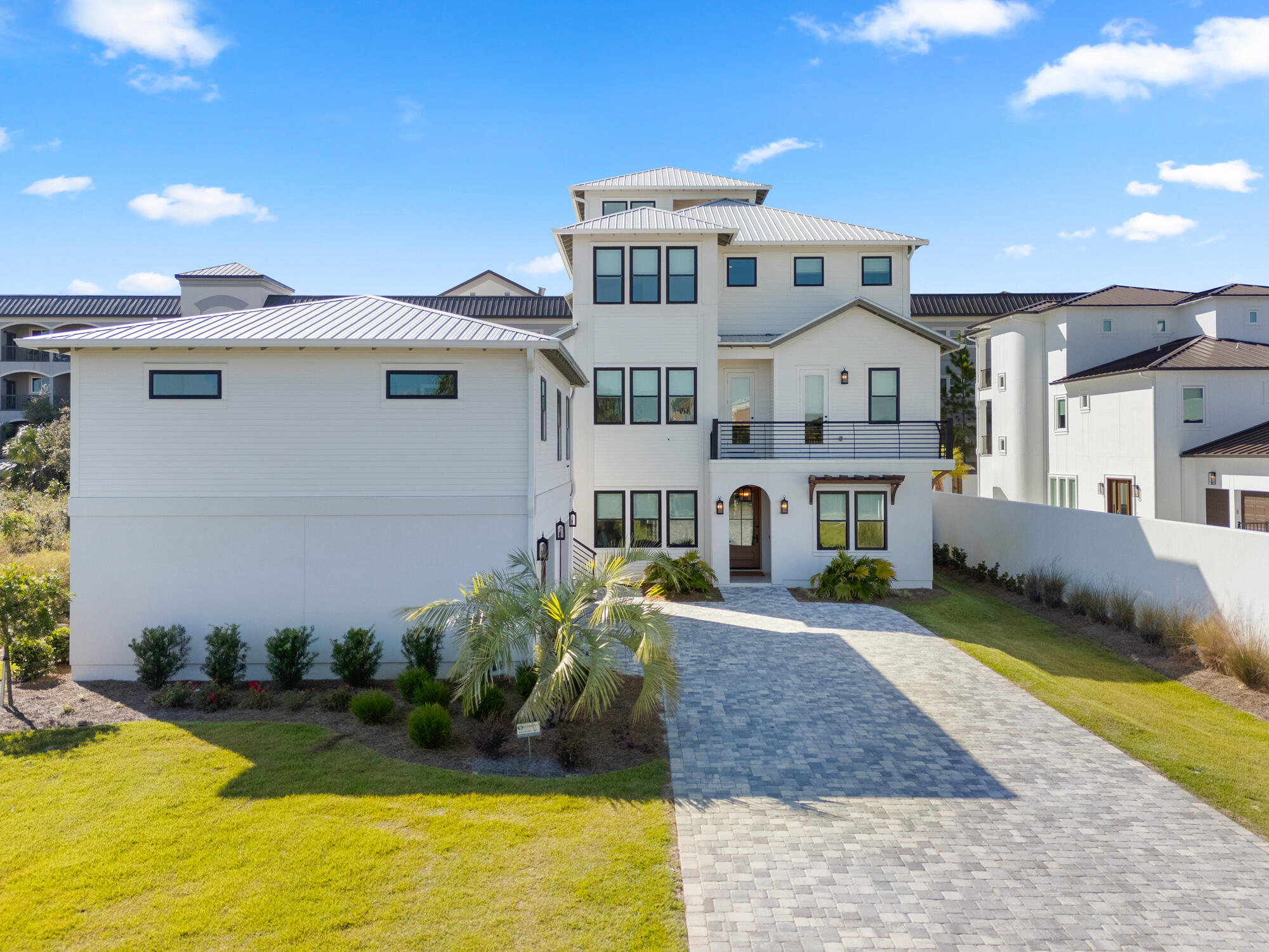 Discover unparalleled luxury in this expansive 2023 built nine-bedroom residence located in Miramar Beach, just minutes from the pristine sands of the Gulf of Mexico. The home features seven king suites and two bunk rooms, complemented by nine full bathrooms and four half baths, ensuring ultimate comfort and privacy for all guests. Thoughtfully designed with custom-curated art and decor, the interior exudes coastal elegance with shiplap walls in various areas and wood-trimmed ceilings enhancing the 2nd floor open-concept kitchen, living, and dining areas. Upon entry, the main level offers private king suites with en-suite bathrooms, a bunk room with six built-in twin beds and its own bathroom, plus a guest half bath. An elevator provides easy access to all levels. The poolside game room invites friendly competition with a ping pong table, shuffleboard, two smart TVs, and a custom lounge area, opening directly to an entertainment-focused backyard oasis.

The expansive outdoor area features a covered summer kitchen equipped with a grill, ice maker, sink, wall-mounted outdoor TV, and Sonos sound system, plus a convenient half bath. The centerpiece is a heated pool with a waterfall wall, built-in concrete stools, and a luxurious spa. Surrounding amenities include hammocks swaying in the breeze, a three-hole putting green, fire pit area, lush tropical landscaping, ambient lighting, and a pergola with outdoor seating and caf?? lights enhancing the resort-like ambiance.

Ascend via elevator or shiplap-accented staircase to the second floor, where a chef's dream kitchen awaits. It's equipped with luxury Caf?? series appliances including a refrigerator, gas range, two dishwashers, beverage cooler, ice maker, and a large island with additional seating. The adjacent dining area comfortably seats all guests, accented by unique vintage-style local artwork. The adjoining living area includes a large wall-mounted TV, chairs, and sofa for peak relaxation. This level also hosts king suites with tiled walk-in showers; one suite additionally features a separate clawfoot bathtub, offering serene retreats for guests. A small front balcony accessible from one of the bedrooms and a hallway provides multiple vantage points to enjoy the surroundings, while a large covered rear balcony overlooking the pool area offers both shaded and unshaded spaces ideal for morning coffees or evening cocktails.

On the third floor, an entertainment haven awaits with an additional living area featuring a wall-mounted TV, comfortable sofa, and three arcade cabinets, creating the perfect spot for family fun and leisure. A convenient coffee bar equipped with its own ice maker and drink cooler adds to the allure. Between the king suites with luxurious walk-in tiled showers, there's an additional sitting area with a built-in countertop. For larger groups or families, an additional bunk room accessed through a barn door features four custom-built bunks and an en-suite bathroom thoughtfully integrated to accommodate everyone's needs. A large covered balcony with outdoor seating overlooks the pool area, accessible directly from the bunk room and the living area.

At the pinnacle of this exquisite home, the rooftop bar and lounge offer a space designed to elevate your experience both literally and figuratively. This rooftop oasis blends relaxation and entertainment, featuring a unique bar area with charming swing seating and a wall-mounted TV. Enjoy views of the Gulf of Mexico from both covered and open seating areas. Under the shaded section, unwind with a refreshing drink, while the open seating area centers around a fire pit perfect for evening conversations.

An adjacent carriage house offers a private and luxurious retreat, perfect for couples seeking extra privacy or guests desiring a secluded getaway. It features a spacious bedroom suite, a spa-like bathroom with a jetted soaking tub and a tiled walk-in shower featuring a rainmaker showerhead and additional water controls, complemented by a mirrored changing room. The kitchen boasts stainless steel appliances including a refrigerator, ice maker, and dishwasher alongside custom cabinets and open shelving. A comfortable living area furnished with a sofa and a wall-mounted TV provides an inviting atmosphere for unwinding after a day at the beach or exploring local attractions. Beneath the carriage house are two single garage stalls one equipped with an EV charger and an additional washer and dryer provide convenience and cater to larger groups, ensuring a seamless experience for all guests.

Following a successful inaugural year on the rental market and with bookings already secured into 2025, this property is not just a luxurious residence but also a promising investment. Meticulous attention to detail, captivating architectural elements, and a stunning array of carefully curated artwork create a vibrant atmosphere, blending sophisticated design with luxury amenities and a promising start in the rental market. 

Immerse yourself in a lifestyle that seamlessly blends luxurious interior comforts with exquisite outdoor amenities. Tailored for those who appreciate the finest in coastal living, this exceptional residence is conveniently located south of US Hwy 98 in Miramar Beach just minutes from the beach, shopping, restaurants, entertainment, and the pedestrian path that runs the entire length of Scenic Gulf Drive. Don't miss the chance to experience this unparalleled luxury retreat.