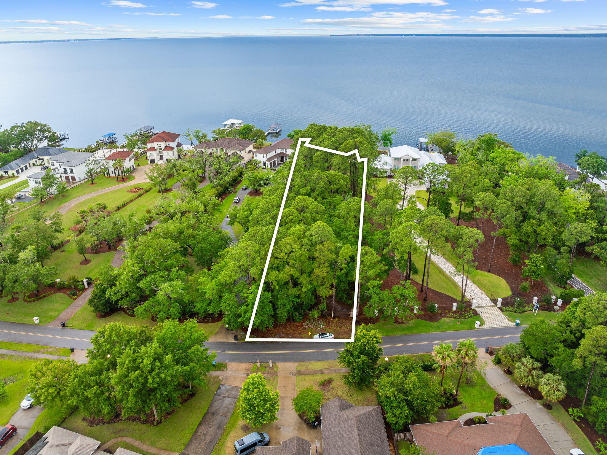 Prominently positioned with exceptional naturalistic beauty, this estate-sized homesite is one of the last remaining vacant lot opportunities available on prestigious Driftwood Point, located on the highly coveted west side of Driftwood renowned for its breathtaking year-round sunset vistas. This sprawling legacy property spans an impressive 1.2 acres, offering unparalleled privacy with a substantial 86 feet of pristine water frontage and lot width and extending a remarkable 600 feet in depth. Positioned perfectly to capture the enchanting beauty of the western horizon and all day southern sun exposure, this lot yields a rare opportunity to design an architecturally significant and private estate where each evening brings a stunning display of vibrant vistas, reflected in the tranquil waters and natural surroundings of the Choctawhatchee Bay.
This home site has proportions that are rarely replicable anywhere along the Bay in Northwest Florida with an enviable location promising an unrivaled lifestyle of luxury and seclusion. Driftwood Point provides an exceptional array of lifestyle amenities including a neighborhood park complete with tennis and pickleball, acres of walking trails and event space as well as a playground for kids and families to enjoy, all of which is in excellent proximity to world class white sand beaches and Florida State Parks as well as upscale restaurants, shopping and entertainment accessible by car, golf cart and boating proximity! This property has a floorplan and dock plan available for review and also has nearby Sandestin Marina as a convenient fuel stop for avid boaters!