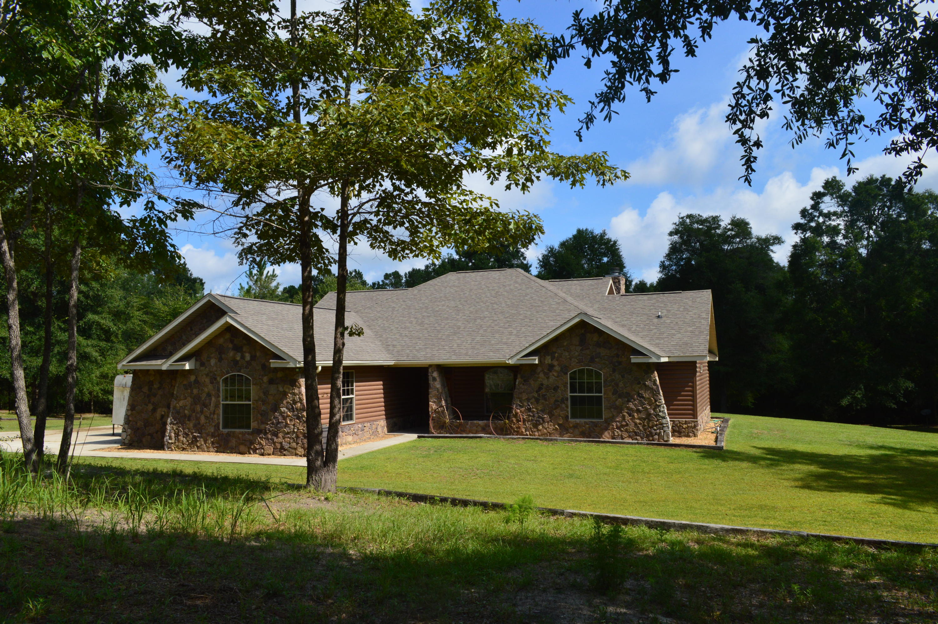 If you are looking for plenty of room and privacy for the whole family, then look no further! Country estate with a spacious main home that features nearly 2400 sf with 3 bedrooms and 2 baths. Home features a chef's kitchen with tons of cabinets and counter-space and a great propane stove and oven, as well as a breakfast bar. Kitchen is open to the expansive living room with rich hardwood floors and a fireplace and mantle made from wood that came from an Alabama church built in 1902. Living room also features a trey ceiling with rope lighting. Bedrooms are very spacious and have plenty of natural light. Master bath features his and hers vanities and a large shower and master closet features custom shelving. All of this on 5 acres. Call today!