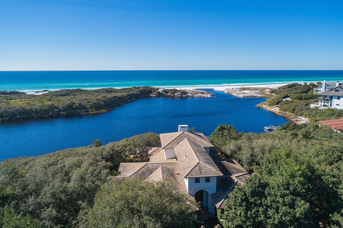 Masterful concrete construction paired with a rich historical and architectural significance characterize this exceptionally located beachside retreat in the exclusive gated enclave of Redfish Lane. Primely positioned on .82 acres of land, this rare estate-sized property provides an astounding 220' of water frontage perched on an elevated bluff overlooking the Gulf of Mexico and Little Redfish Lake with insulated privacy from the majestic dune topography at Grayton Beach State Park allowing for an unparalleled naturescape.