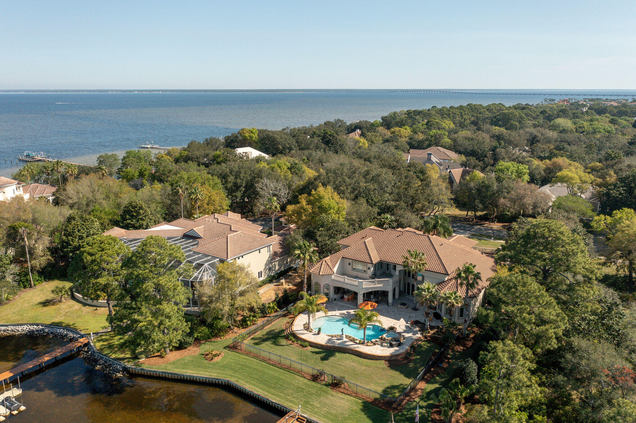 Rare opportunity to own a luxury residence offering waterfront living and boating at it's best! Situated on wide, deep water within the gates of desirable Kelly Plantation, on a lot graced with mature live oaks and magnolias, with 145 feet of bayou frontage. Meticulously designed for gracious entertaining and family living, with no details overlooked and a well designed floor plan that utilizes every inch of space. Fabulous curb appeal, with a brick paver circular drive and porte-cochere and gorgeous hand forged double wrought iron doors opening into a grand foyer, living room with soaring 23 foot coffered ceilings, the adjoining formal dining room and a handsome study/library with custom mahogany built-ins. The luxurious master wing is to the left...and is nothing short ofopulent, with a