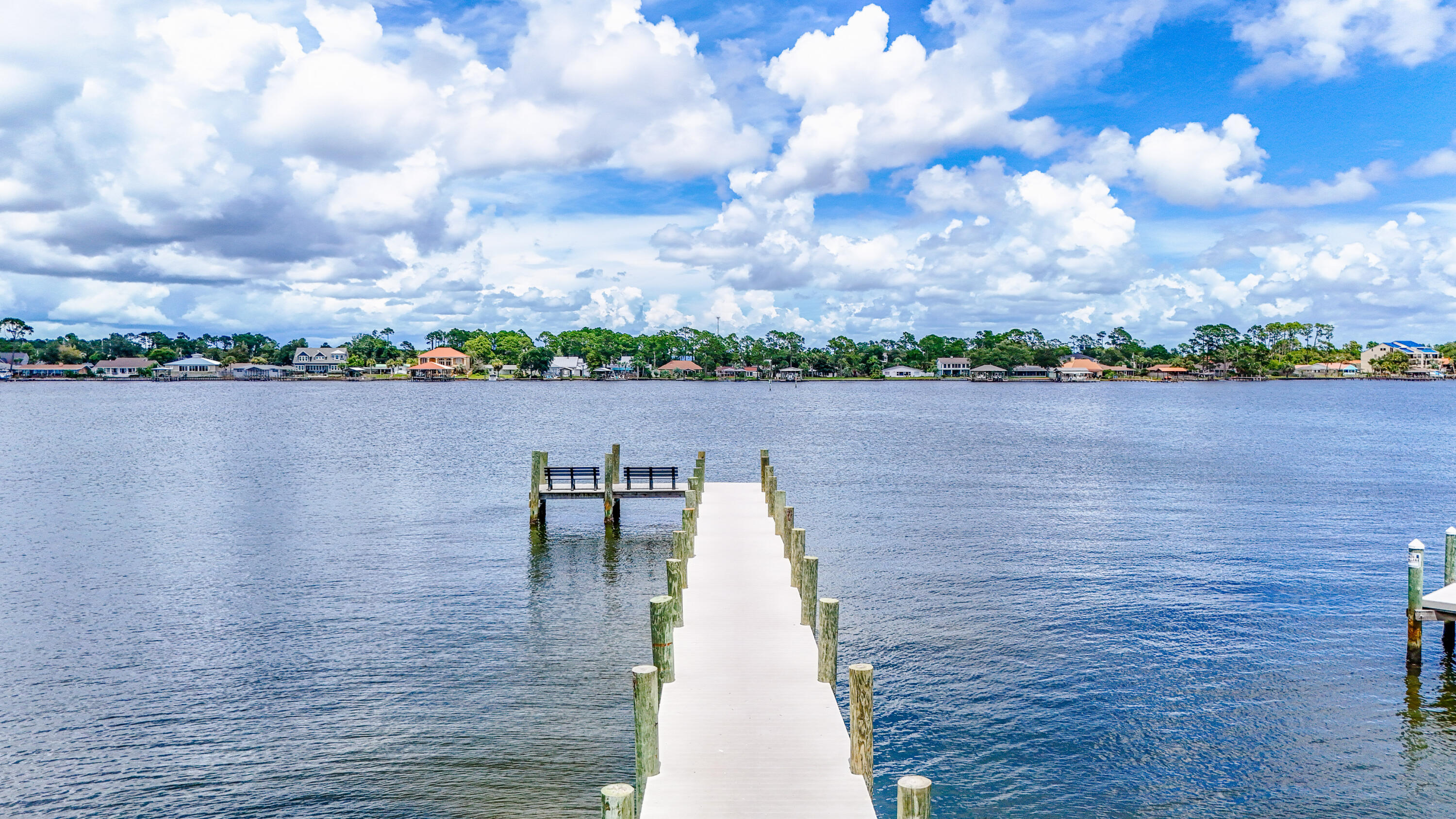 Absolutely Adorable Beach Bungalow located across from the Dolphin Boat Ramp on Grand Lagoon!! This block home has been updated with new impact resistant windows 2019, new trusses and roof 2022, new master bathroom 2022, new HVAC 2023, and new septic in 2019. The outdoor living from the front porch to the backyard patio provides lots of space to gather with friends and family or just sit outside and enjoy the peace and quiet. The Grand Lagoon is right out your front door; go fishing, paddleboarding, boating, or jet skiing. Although quaint and cozy there is plenty of room with 2 bedrooms, 2 bathrooms, open living room and kitchen, separate dining room, cozy den and reading area with lots of natural light. The workshop is a great place to store all of your beach toys, golf cart or a small vehicle.
Location is perfect!! You can easily get to the beach, lagoon, marina and St Andrews State Park in a matter of minutes. Enjoy great options for entertainment, dining, shopping and excursions. This property is just a few miles from the Publix Sports Complex and Pier Park. Yet, the neighborhood is set back for some quiet time when you're ready to relax.