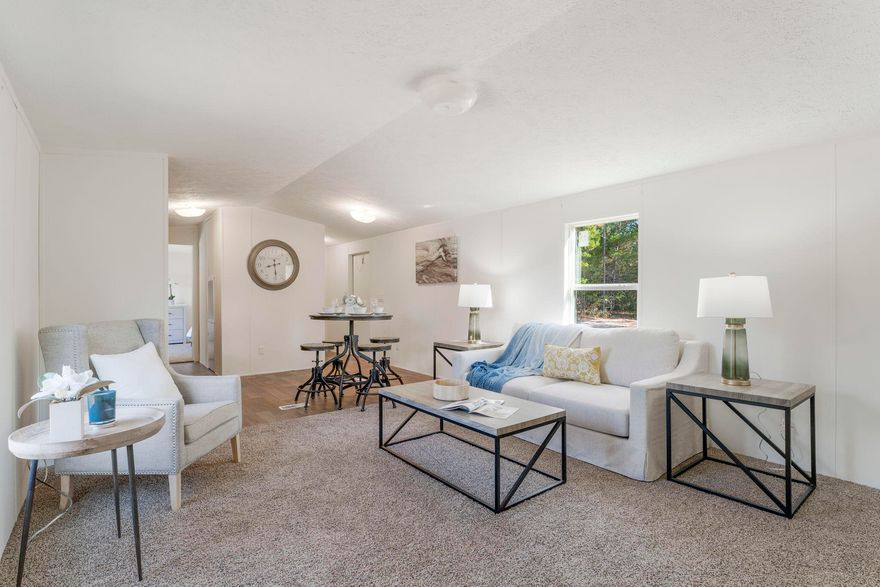 PRICE IMPROVEMENT!! Welcome to this charming 2019 manufactured home offering three bedrooms and two bathrooms, situated on a generously sized lot. As you step inside, you'll find a residence that has been thoughtfully upgraded with care and attention to detail. Experience the warmth of new carpeting, the freshness of recently applied paint, and the allure of stylish new light fixtures that collectively create an inviting and cozy ambiance, ideal for unwinding after a long day. The home boasts a recently added kitchen backsplash, introducing a touch of elegance to the already functional kitchen. An updated driveway not only enhances the curb appeal of the property but also ensures convenient access for your vehicles.