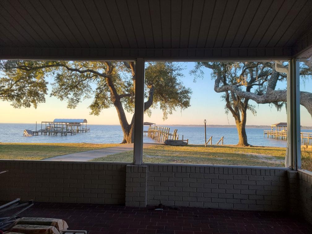 This amazing bay front open floor plan has paradise in the back yard. With a large screened in porch, fire pit, dock, boat ramp. Large oak and magnolia trees surround this .46 acre lot. Garage for 4 cars and a massive driveway for more cars. Have an RV? There is also space to park your RV right at your home. Inside has a propane gas fireplace, granite countertops in the kitchen and lots of views from inside looking at the beauty out back. Plus so much more. For your private tour call today.