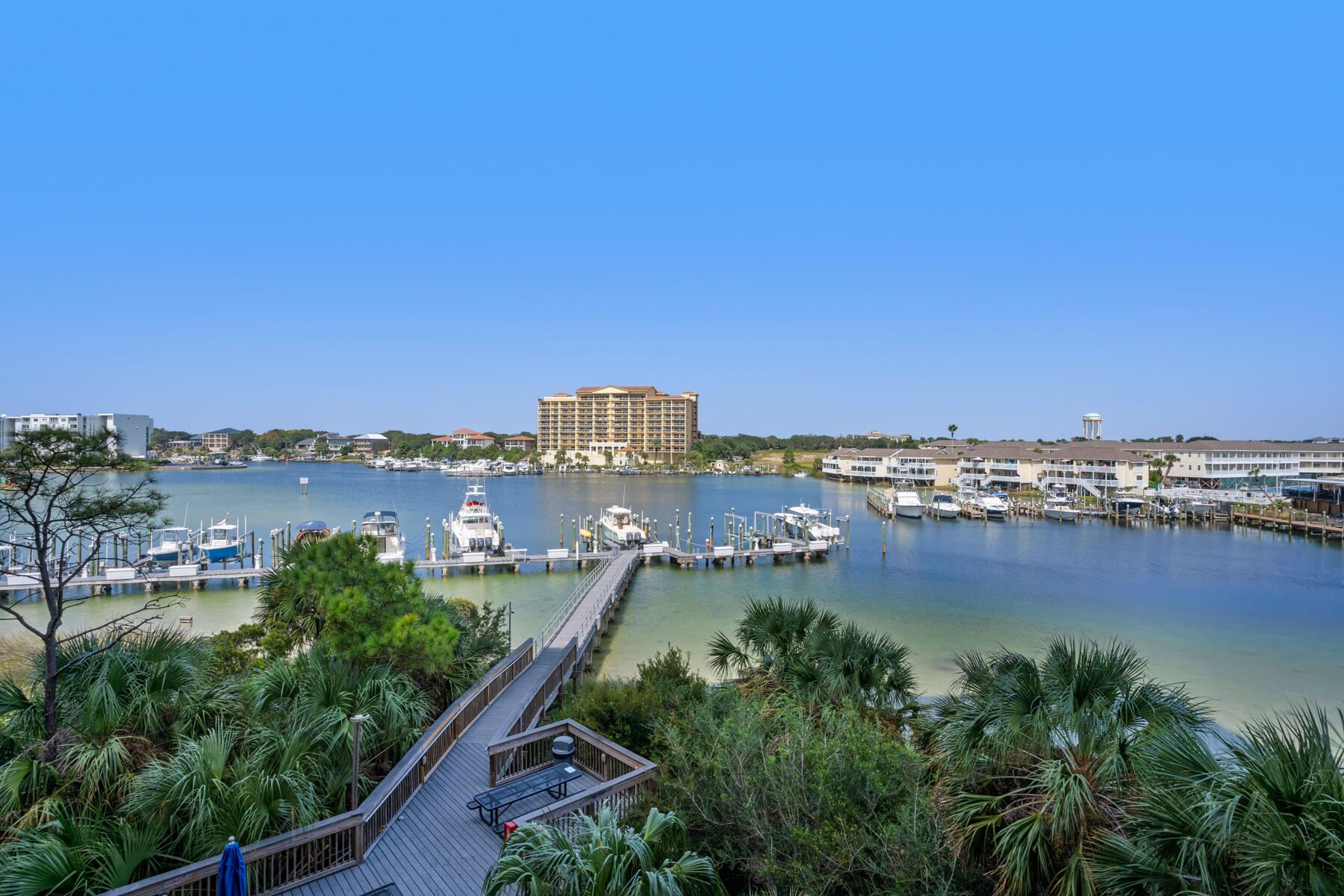This luxurious harbor-front condo is a paradise for those who embrace both beach and boating lifestyles, offering the quintessential Florida experience. With a generous deep-water boat slip and convenient covered parking, it seamlessly blends the best of both worlds, creating the ultimate Florida lifestyle.Upon entering, you'll discover one of Harbor Landing's most sought-after floorplans. The open living area, kitchen, and dining space exude the comfort and warmth of a residence, setting it apart from the typical condo. The expansive balcony, overlooking the harbor, provides an ideal setting for relaxation and dining while you soak in the breathtaking waterfront views. The open-concept design, complemented by high ceilings, fills the space with natural light, creating an inviting