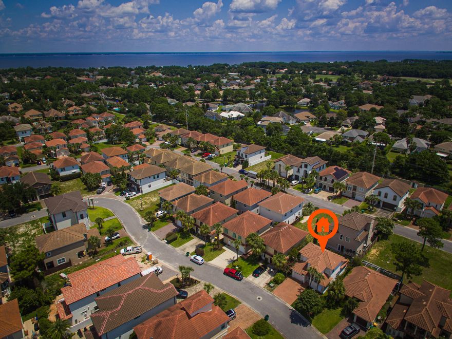Imagine enjoying morning coffee in your lush garden, tucked away in a gated community one mile from the beach in Destin! This sophisticated tile-roofed home features a paved driveway and dramatic 2 story windows. Upon entering, crisp white walls counter the slate gray porcelain tile throughout the main floor. Soaring ceilings and crown molding accent the open concept kitchen, dining, and living area. Kitchen has stainless GE appliances, copper sink, burnished bronze faucet, Bosch dishwasher, and porcelain panel backsplash. Walk-in closet and newly redone ensuite bathroom add to the master bedroom on main floor. New gray carpet covers the 2nd floor and stairs. Contemporary sink and new granite countertop adorn the bathroom. Take your golf cart to nearby shopping and golf.