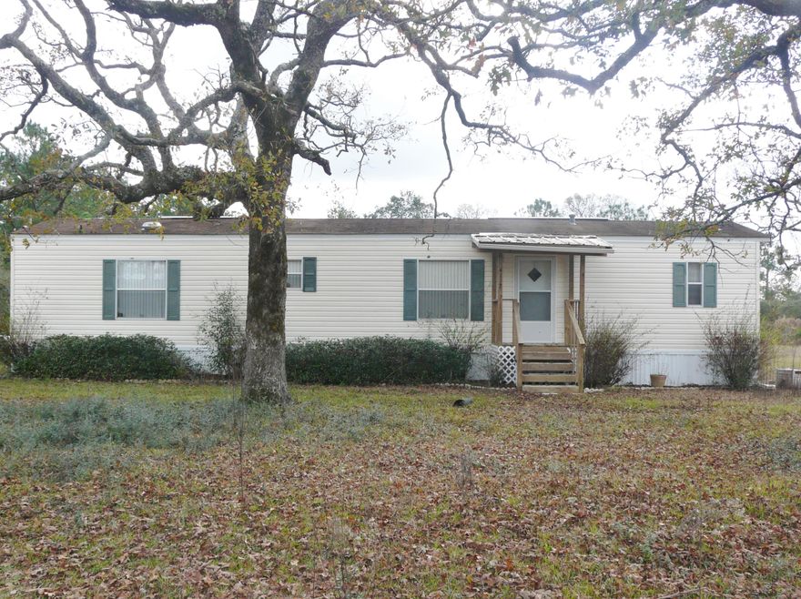 One acre in the country just outside town with nice new porches to sit and relax. No city taxes. Built in 2002, and plenty of room to entertain in large living room and kitchen. Two bedroom, two bath home with a lot of parking area and room to play ball with the kids or friends. Wonderful old trees and plenty of room for garden. Yard fenced on three sides. Come see this home at fantastic price. Outside shed does not stay.