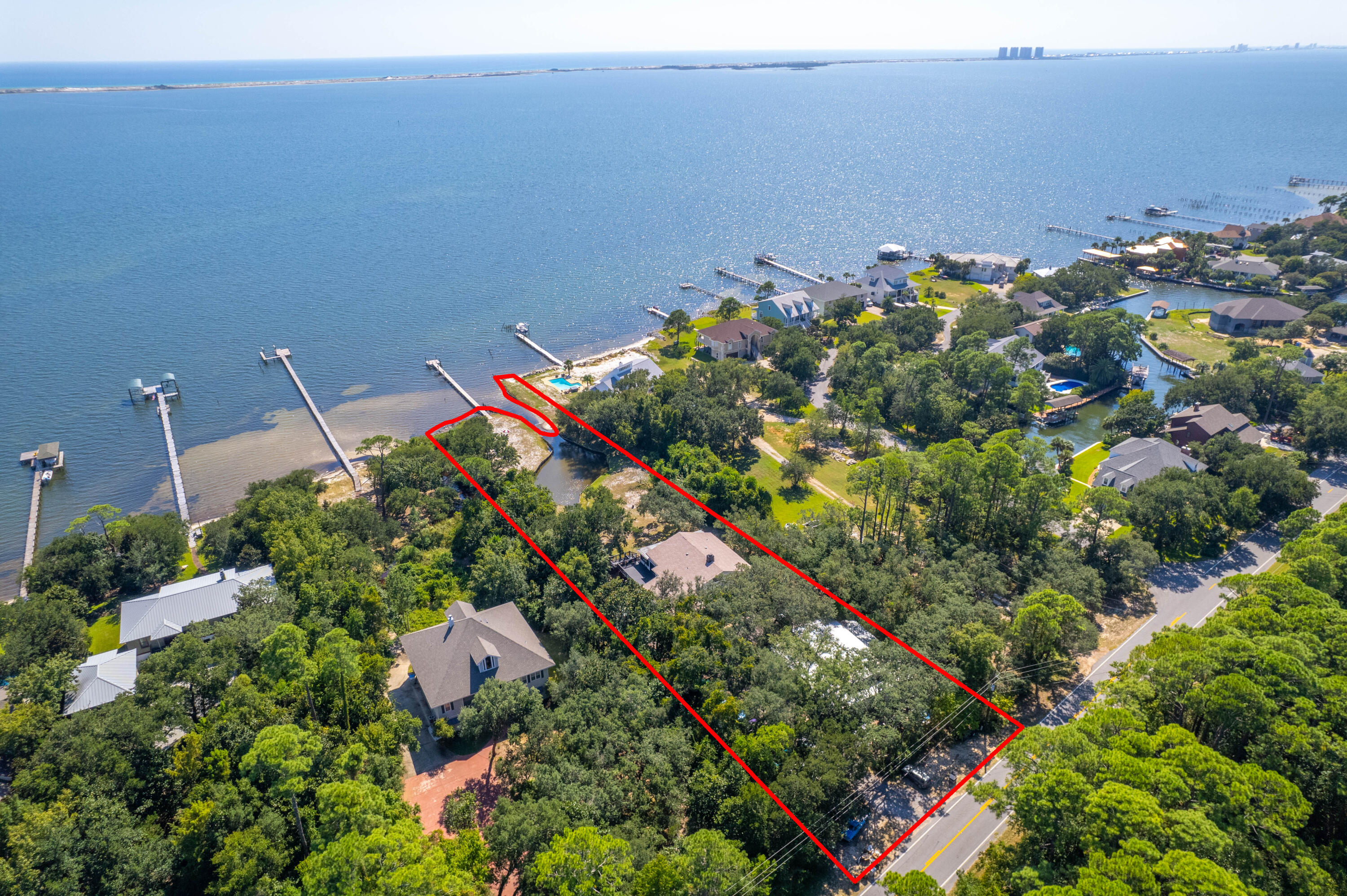 *BACK ACTIVE AT NO FAULT TO THE SELLER* Located directly on the Santa Rosa Sound on 1.21 acres, this private, unique property offers garage space for 10 to 12 cars, 4 bedrooms all with en-suite bathrooms, and a dock with a seawall in place. You enjoy the mature oak trees encompassing the house and the bonus space downstairs that would make a perfect gym, office, or storage space. The main living floor hosts 3 bedrooms and en-suite bathrooms with a powder room, a massive living room (33'x19') with high ceilings, and 2 separate dining areas. Note the wood accent details, including all handmade, unique solid wood doors throughout. The over-sized primary suite is on the third floor and offers wonderful sound views with a spacious walk-in shower with dual shower heads. Relax on the large open d