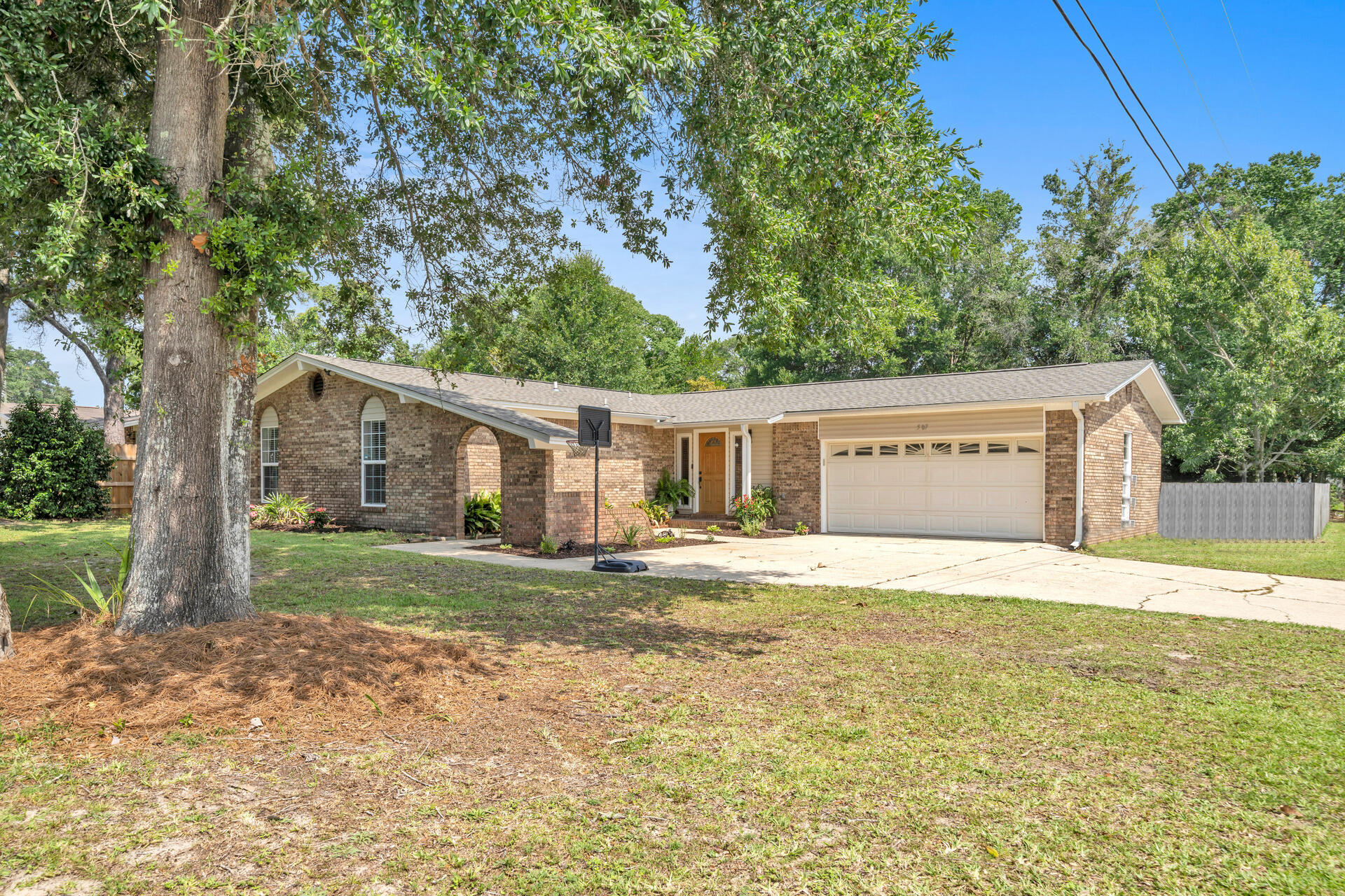 Updated 3 bedroom and 2 bath brick home with 1575 sq ft located across the street from Cinco Bayou and centrally located in Fort Walton Beach, FL. This home is close to the military bases, shopping, restaurants, and excellent schools! The roof was updated in 2023 with a 30 year dimensional shingle roof, new hot water heater (2023), new LVT flooring, and remodeled kitchen and bathrooms! This home has a nice foyer that connects to two living room spaces! The first living room has all glass doors to an open patio and the second living room space features a fireplace and sliding glass doors. The large galley kitchen features a stainless side by side refrigerator, dishwasher, and stainless and black slide in stove and built in microwave. The natural wood tone cabinetry pairs nicely with the modern tiled floors, granite countertops and tiled backsplash. The kitchen opens to the living room and a dining room. The master bedroom features an ensuite bathroom with a custom tiled shower, frameless shower door, and updated vanity, mirrors, cabinet hardware, faucets and fixtures. There are two additional guest bedrooms. The guest bathroom features an oversized vanity, new custom tiled backsplash, mirror, lighting, hardware, faucets and fixtures. There are also some new light fixtures throughout the home, wainscoting in the bathrooms, baseboards, raised panel doors, ship lap on ceilings and walls, and 2 inch vinyl blinds. Exterior features include a privacy fenced back yard, a two car garage with a work sink, built in cabinetry and a smart garage door opener, a gutter system, concrete driveway with extra parking area, mature landscaping, an outdoor shower, and covered patio and open patio. There is also a storage shed. The covered patio is wired for a flat screen TV and has an outdoor ceiling fan. Buyer to verify all dimensions and information.