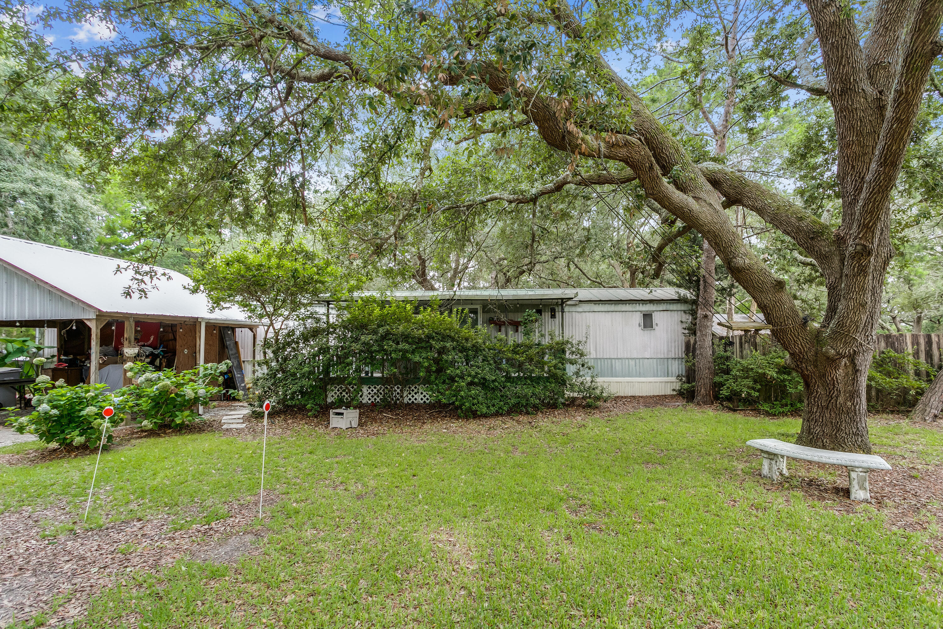Back on the market, no fault of the seller! Beautiful property that sits on just over half an acre with mature oak trees providing a unique opportunity to own in Navarre. The property has a mobile home on it that currently rents for $850/month, and a cabin located at the rear of the property. The mobile home is 3 bedrooms, 2 bathrooms, has a newer metal roof, carport with separate driveway, storage shed, septic tank and the appliances convey. The cabin is a 1 bedroom, 1 bathroom with a kitchen, separate driveway, septic tank, carport, shed and the grill/appliances convey. There is a privacy fence that separates the 2 homes. Make this your primary residence or a dual income property!