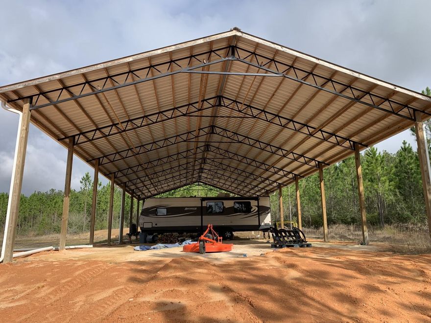 1 acre is cleared and there is a 84' x 36' pole barn with gutters. Underground electric. Power includes an RV hook up. RV does not convey. There is a septic tank in place that is not currently hooked up, just waiting for your new home construction.