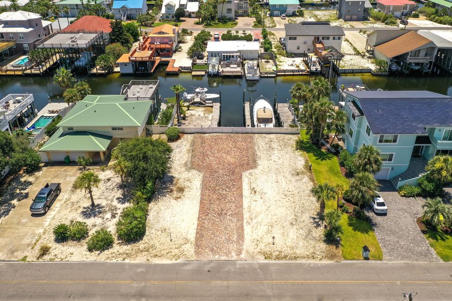 Attention boaters!!  Situated ideally on Holiday Isle, this canal front lot is close to all the conveniences Destin offers. Design your custom coastal retreat and capture expansive gulf and harbour views from this location.  Two deep water slips, can accommodate boats up to up to 50' and there is a 10,000 pound Breeze boat elevator lift for a 26' boat.  Two spaces are currently rented and can likely be negotiated.  With only a short distance to the beach, the water, electric and sprinkler system are  already in place.  Sewer connection has been paid but still has to be connected.