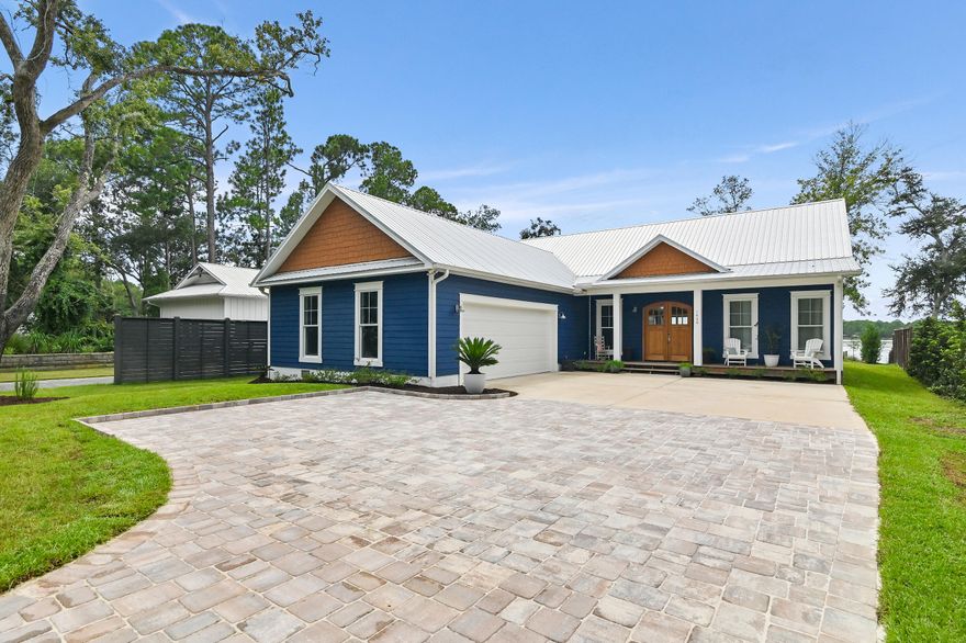 Indulge in the pinnacle of bayfront luxury with this exceptional custom-built waterfront estate on over half acre designed with room for a pool, nestled along the serene Lagrange Bayou perfectly juxtaposed to offer one of the only true westerly sunset views on the bayou, yet tucked back just enough to avoid high north/south wind gusts off the bay making for peaceful and pleasant outdoor experiences. AMAZING LOCATION, LOCATION, LOCATION just 3 minutes to shopping or the 331 bridge from Lagrange Rd., less than 10 minutes to the Hwy 98 to traverse anywhere east or west in the panhandle, and finally just 15 minutes from the world-renowned sugar-white sand beaches along 30A and the emerald waters of the Gulf of America, world-class golf courses, unrivaled fresh seafood and exquisite coastal cuisine. The private dock makes boating to North Beach Social and The Bay restaurant effortless, both just a scenic 10-15-minute boat ride away. 

It's truly the best of all worlds where you enjoy the small town charm of a friendly bay community with NO HOA that is SO CONVENIENT to everything you need in-town just around the corner from boutique shopping and the constantly growing commercial retail such as Publix just minutes away and the new Wal-Mart being developed. You are less than 40 minutes to the International airport (ECP) in Bay County, FL and 45 minutes to VPS Niceville airport that also provides additional travel times and destinations. Boat rides 15 minutes cruise to dining at The Bay and North Beach Social. 35 minutes East or West to fishing in the Gulf.

Masterfully built and thoughtfully designed, this residence was constructed in 2022 and combines elegant coastal architecture with modern functionality, offering approximately 104 feet of private shoreline (partly beach shoreline), a 30-foot boat lift, and deep water access  perfect for yachting, paddleboarding, or tranquil sunset cruises. 

From the moment you arrive, a newly installed paver driveway sets the tone with elevated curb appeal, guiding you toward a home that radiates warmth, sophistication, and understated opulence. Inside, the residence features rich hardwood flooring throughout, soaring ceilings, and a chef's kitchen adorned with premium stainless steel appliances, lavish granite countertops, custom backsplashes, and bespoke cabinetry. The primary suite offers a walk-in closet that connects directly to a custom-designed laundry room, complete with ample cabinetry, a utility sink, and striking brick-style flooring that adds character and charm.

Designed for both relaxation and entertaining, the west-facing backyard captures stunning sunset views and boasts a spacious covered deck with a fully equipped, custom-tiled summer kitchen. Outfitted with a built-in gas grill, cooktop, and sink, this space invites unforgettable evenings with friends and family along the water's edge. 

With the added assurance of being located in a flood zone AE-8 and zone X as confirmed by a recent flood certification survey (so flood insurance is not required and nominal in cost should you choose to purchase), this one-of-a-kind home is not only beautiful but built for peace of mind. Whether you're searching for a luxurious primary residence or a turn-key second home convenient to 30A and literally everything you need, this Lagrange Bayou masterpiece offers a lifestyle defined by elegance, ease, and unparalleled waterfront living.