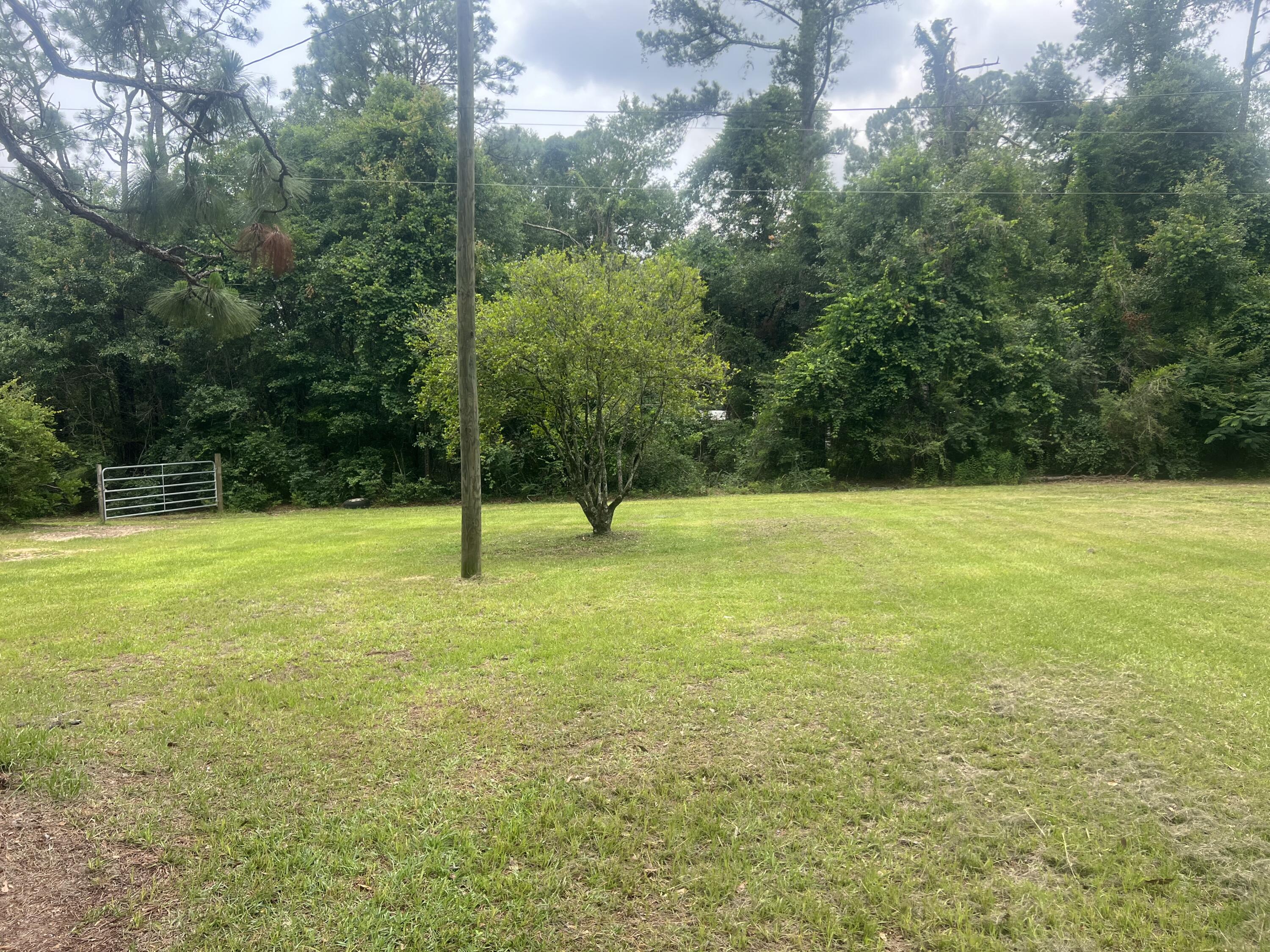 Beautiful piece of paradise in the heart of Baker. This 2.41 acre lot is complete with two septic tanks, city water and two power poles. There is a dividing tree hedge so you can put two manufactured homes on the property. Surrounded by camellia's, azaleas and blueberry bushes and Gardenia's. Don't wait, bring your house plans and build your dream home today. Chicken coop conveys with property AS IS.