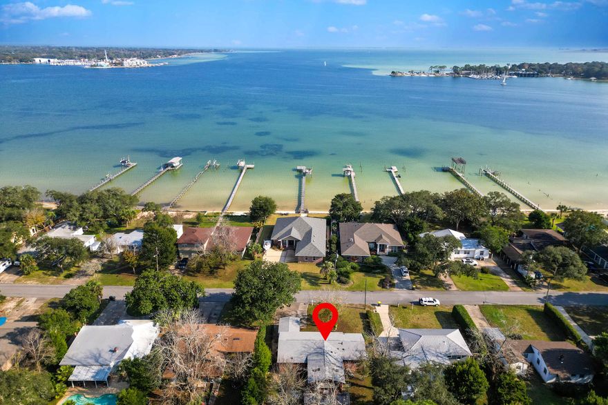 ACROSS FROM THE BAY.. STEPS FROM GARNIER BEACH PARK.. MINUTES FROM EGLIN AFB.. WITH CUSTOM POWERED WORKSHOP.. NEW PLUMBING.. NEWER 30-YEAR DIMENSIONAL ROOF.. AND THIS HOME CONVEYS FULLY-FURNISHED!!!Welcome to 266 NE Beachview Drive! This 3 BR/1 Bath.. PLUS BONUS ROOM (with additional space for 2nd bath).. offers multiple design options and boasts BAY VIEWS from various rooms.The owner painted the entire home.. ripped out the carpeting.. and installed luxury vinyl plank flooring over the original hardwood floors. She updated the bathroom to include NEW TUB/SHOWER COMBO.. and NEW LIGHTING. She also purchased NEW APPLIANCES!GORGEOUS CALIFORNIA REDWOOD ceilings/paneling remain in areas... as well as beautiful built-ins and archways indicative of the era.#KeepReading Common areas include a formal living room, formal dining room, family room, bonus room, a single-car converted garage (currently used for storage).. and my favorite feature of this property-- the POWERED WORKSHOP WITH BUILT-IN TOOLS!

The workshop is LARGE and comes equipped with built-in compressor and built-in welding station. Think of the projects you could do! Other possibilities for the space include: artist retreat, yoga space, or studio apartment (with sweat equity.. of course). Airbnb??

There's an expansive deck with retractable awning (perfect for grilling/barbeque), several fruit trees.. and a firepit! The backyard is fully-fenced and will easily accommodate pets and children.

Speaking of pets and children.. I did mention you were steps away from Garnier Beach Park. This park includes a small beach, a boat launch, a playground and a picnic area. You also have fantastic views of the bay.

BONUS: Less than 10 minutes away from Fort Walton Beach Medical Center!

Just to recap.. bay, park, powered workshop, newer roof, new plumbing, recently renovated, and quick commute to the base. 

Better hurry!
