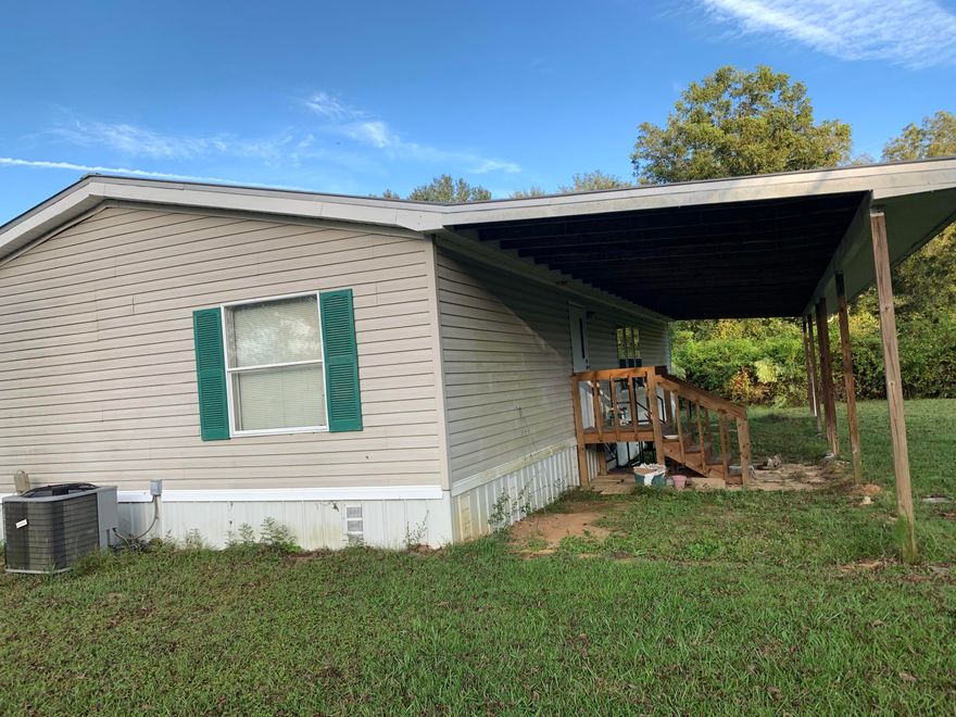 PRICE REDUCED!  Plenty of elbow room on this 51 acres with manufactured home.  About 29 acres of wet land on Southern portion of parcel.  Home has covered porch across entire front.  In rear, there is a 12 x 52 covered area with room for parking.Large living room and split bedroom floor plan. Carpeting looks new and home shows no signs of repairs needed.  Master bath is spacious with double sink vanity and large shower. Kitchen has lots of cabinets.  Yard has a few big pecan trees, a fig tree, and several grape vines.  There are  about 12 acres of planted pines behind home planted in 2017.  Metal storage building and two semi trailer storage units on property. Fronts paved road near AL line.