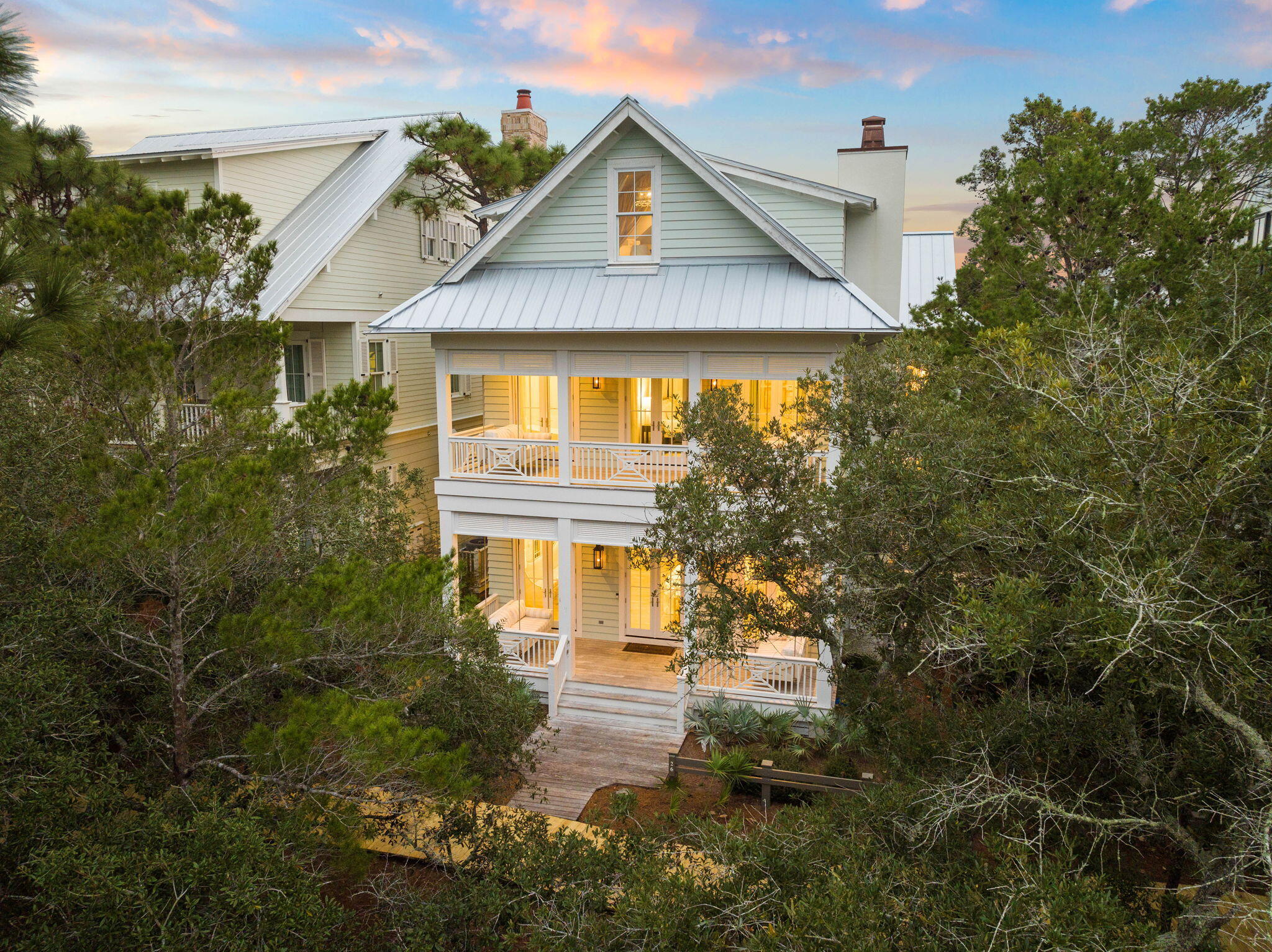 This spacious custom residence is a masterpiece of design and quality craftsmanship, as reflected in the impressive rental figures of over $400k in 2023. Masterfully designed by Gregory Jazayeri, this six-bedroom, eight-bath residence in WaterColor features a private pool and spa, a two-car garage with a full carriage house, and much more. The front of the home boasts large porches on both the first and second levels, complete with adjacent porch swings, providing a tranquil outdoor retreat for reading and relaxing. Step inside to discover the stunning open-concept floor plan, professionally decorated with custom furnishings, wallpaper, and finishes from top to bottom. The light-filled living space features a decorative fireplace, sky-high coffered ceilings, and windows with transoms and custom draperies. The gourmet kitchen, the heart of the home, includes top-of-the-line Thermador appliances, double dishwashers, and floor-to-ceiling accordion doors that open to the pool, spa, outdoor shower, built-in outdoor kitchen, and living space. This creates an inviting gathering area for sharing drinks and canap??s al fresco. The fabulous marble-wrapped island floats beneath a beamed ceiling interspersed with dark wood panels. A butler's pantry provides ample storage, including a built-in wine fridge and coffee machine. The adjacent dining room with a custom bench seats 12 comfortably. The adjoining sitting room is artfully crafted for entertaining or relaxing in front of the fireplace at the end of the day, and another set of beautiful French doors extend the living space outdoors. Step out onto the porch and relax on the raised dais overlooking the gently murmuring pool, hot tub, and water feature. A green hedge ensures privacy and tranquillity. Six bedrooms are spread across three floors for privacy and all have full, en-suite bathrooms. Ideal for multi-generational families, there is a stunning king-size bedroom and full en-suite bathroom on the main floor, an adjacent stackable washer/dryer great for after a long day at the pool, and a half bath and mud room leading to the garage. Ascending to the second level, you will find a full laundry room with two more sets of washers and dryers, the main master suite with its own private porch with swings, an additional living area with a Juliet balcony overlooking the pool, and two additional guest bedrooms with full bathrooms. The adjoining carriage house above the garage boasts a comfortable living area with a sleeper sofa that can be closed off by sliding doors, a king-size bedroom, a full bathroom, full laundry, and a wet bar for morning coffee. There is an exterior entry right outside the carriage house interior door. Accessed by stairs or an elevator, the large suite on the third floor has two sets of bunk beds and a curtained area that holds two additional twin beds. The third floor also has a full bathroom adjoining the bunk room, a wet bar with a sink and built-in ice maker, a separate half bathroom, and an additional living space with a TV and sleeper sofa. There's ample parking for guests on the rear driveway or in the two-car garage, currently used as a game room with a ping pong table and couch on one side and to house the golf cart on the other side. Located just a hop from the coveted Frog Pond Pool, a five-minute walk to the boathouse, a five-minute golf cart ride to Camp WaterColor, and a three-minute bike ride from The WaterColor Beach Club, this stunning home is perfectly positioned for enjoying all the WaterColor amenities. Families will love Camp WaterColor with its lazy river, water slides, and zero-entry pool, while adults can ride the bikes over the nearby bridge to Western Lake where fishing and watersports await at the WaterColor Boathouse.