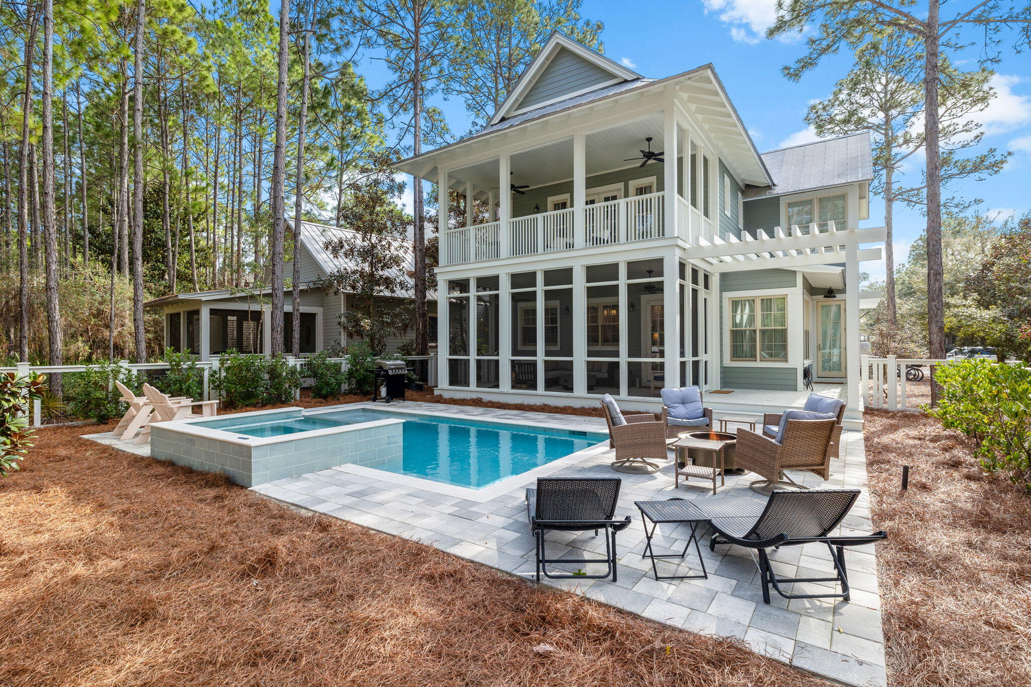 Nestled within tall pines on a quiet residential street, this rental-friendly beach house is the ideal home for those who want an updated residence that's move-in ready. Superbly located in WaterColor Phase II, it's conveniently close to Camp WaterColor, community pools, trails, parks and amenities, including the exclusive Beach Club and Town Center. Backed by a wooded green space and overlooking a small park across the street, this lovely home enjoys exceptional peace and privacy. Recently renovated by local contractor Bill Deisler, and carefully curated internally by architect Kelly May of Southern Lines Design, comfort and luxury are the guiding principles for the magnificent upgrades. Custom details include new kitchen cabinetry, countertops and plumbing fixtures, along with new interior paint. This well-appointed home shows off refinished hardwood floors, stylish new furnishings and new window treatments, making it completely turnkey. Built-in cabinets in the living and dining areas add attractive custom storage with elegant glass doors and designer finishes. White ceiling beams add interest, along with the flickering warmth from the fireplace. The newly enclosed side porch provides a generous area of additional living space. Covered porches on both levels offer additional areas to gather at sunset or use as a quiet retreat. A custom wet bar nook welcomes guests with perfectly chilled drinks and cocktails from the beverage refrigerator. A second drinks refrigerator is tucked in the pantry, which could be repurposed as an owner's closet. The pristine white kitchen combines refined beauty with functionality. A trio of pendular lights hovers above the spacious island with stools lined up for breakfast. The staircase turns as it climbs, creating a semi-hidden office nook in the elbow. Bedrooms and bathrooms on both floors have been similarly updated, including the first-floor powder room. The second-floor master suite is particularly noteworthy, with a lofty apex ceiling and double doors opening onto a covered porch. The luxurious master bathroom boasts a spacious wet room with a twin vanity and a stand-alone tub within the glass shower enclosure. All bathrooms have endless hot water fed by a new tankless water heater. Additional improvements include a new deck off the back porch, new screens, a new HVAC air handler and two compressors. The carport has been re-imagined with a new back door beneath, providing added functionality. The securely fenced outdoor space is truly a showstopper, complete with an oversized pool and bubbling spa. The screened porch offers a comfortable space to relax around the fire pit, making it ideal for all seasons. This fully rejuvenated home delivers exceptional value and convenience, making it ideal as a secondary residence or a luxury vacation home that can easily be rented out when not in use.