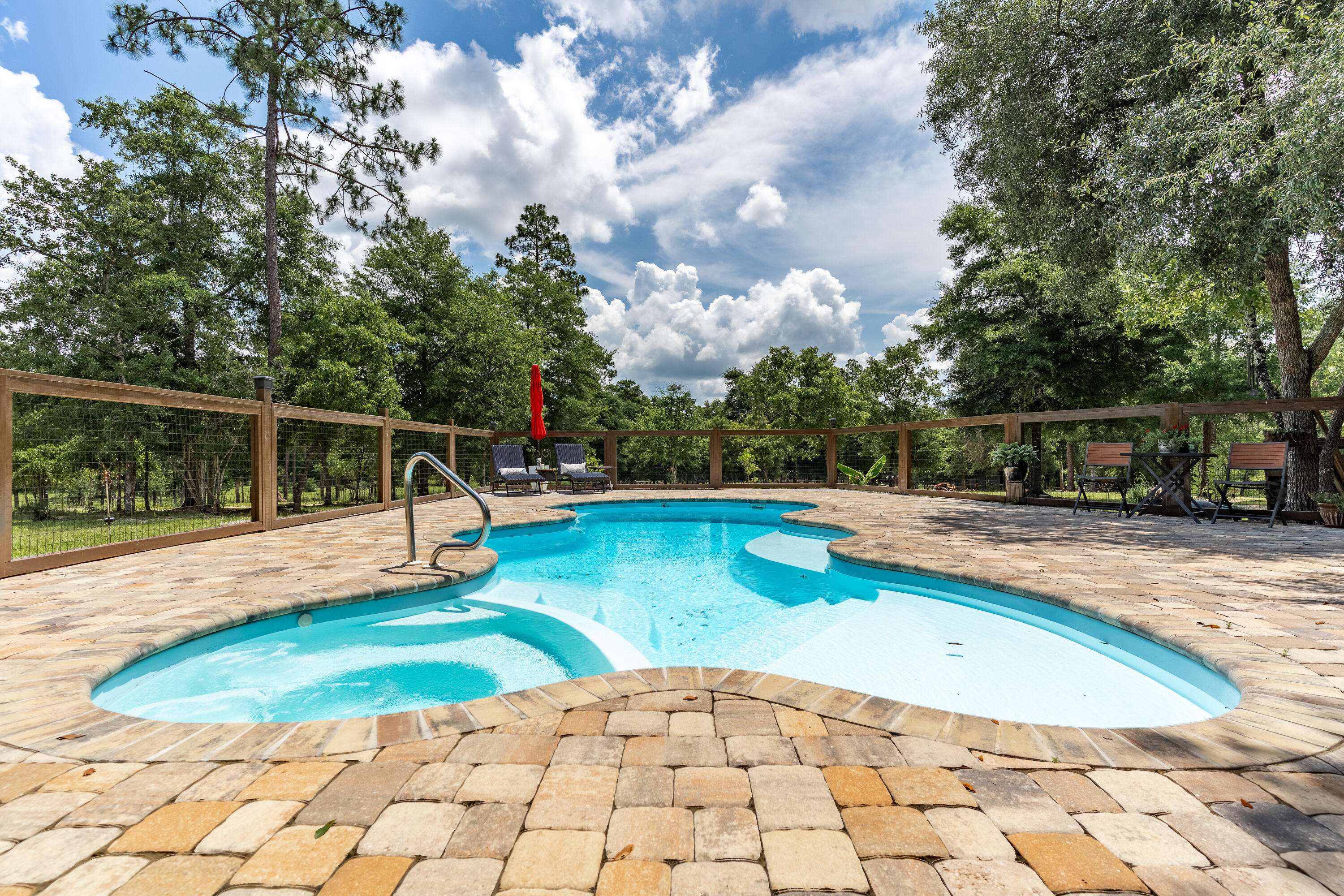 Exceptional opportunity to own a slice of paradise!! This completely fenced-in 23 + acres is away from the hustle and bustle of city life. The property backs up to Yellow River Water Management for privacy. The focal point of the property is the stunning brick home. This immaculate home boasts LVP flooring, granite, gas fireplace and an open floor plan. Plenty of room for family and friends to gather while the breakfast bar seats 6 comfortably. The kitchen is designed with ample granite counter space, custom cabinetry and overlooks the family room. A split floor plan provides privacy for the entire family. A Generac whole house generator will provide you with peace of mind. The property has a 4 stall barn with additional rooms for tack plus 3 additional out buildings. There are two wells. One is 350' while the other is a spring well measuring 125'. They are tied in together. A bubbling stream runs through the property. The diverse wildlife frequents the wooded back of the property. Enjoy swimming in the heated pool with hot tub which measures 14x30. For your convenience there is a shower.
There is so much more to this amazing property that you will need to see it to believe it.