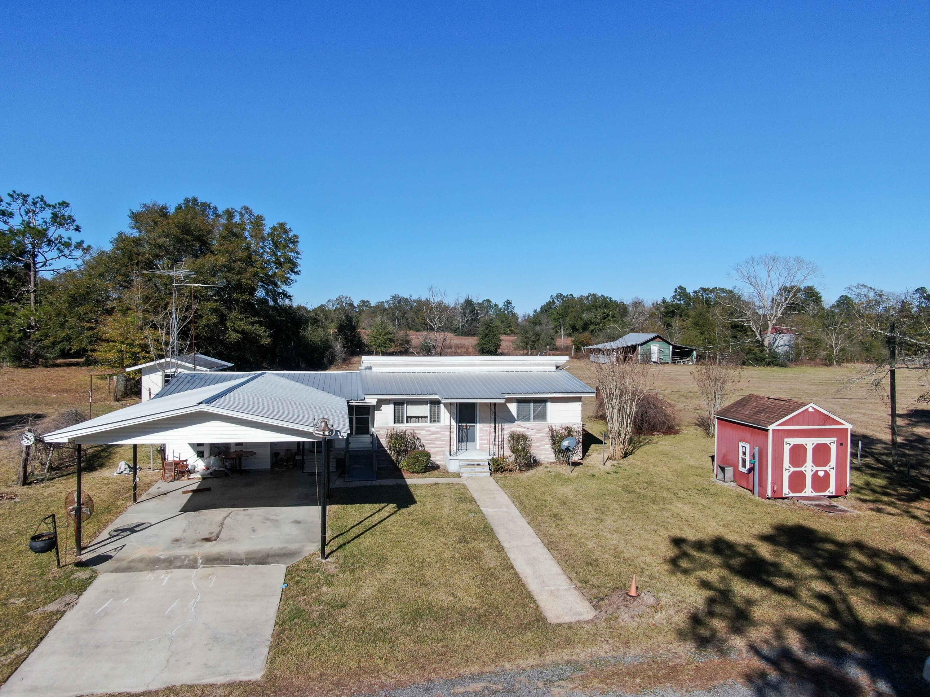 Fixer Upper on 3 acres of beautiful land with a pond in Laurel Hill in the northwest corner of Walton Co, about 20 minutes to Crestview, 5-10 to Florala and 25 to DeFuniak Springs. The home features a metal roof, ponderosa pine interior walls, some tongue and groove walls and a large kitchen with pine cabinets. It is definitely in need of updating and some love but is certainly livable. Could make a temporary home while you build your dream home. Surrounded by larger acreage parcels. Home has not been occupied for many years and is inherited, so owner has little to no knowledge and will not make repairs. There is also a cinderblock outbuilding. Conventional or cash only. The pond is a little over a half acre with the land on a corner of 2 paved roads.10 min to Paxton & 1 hour to Destin.