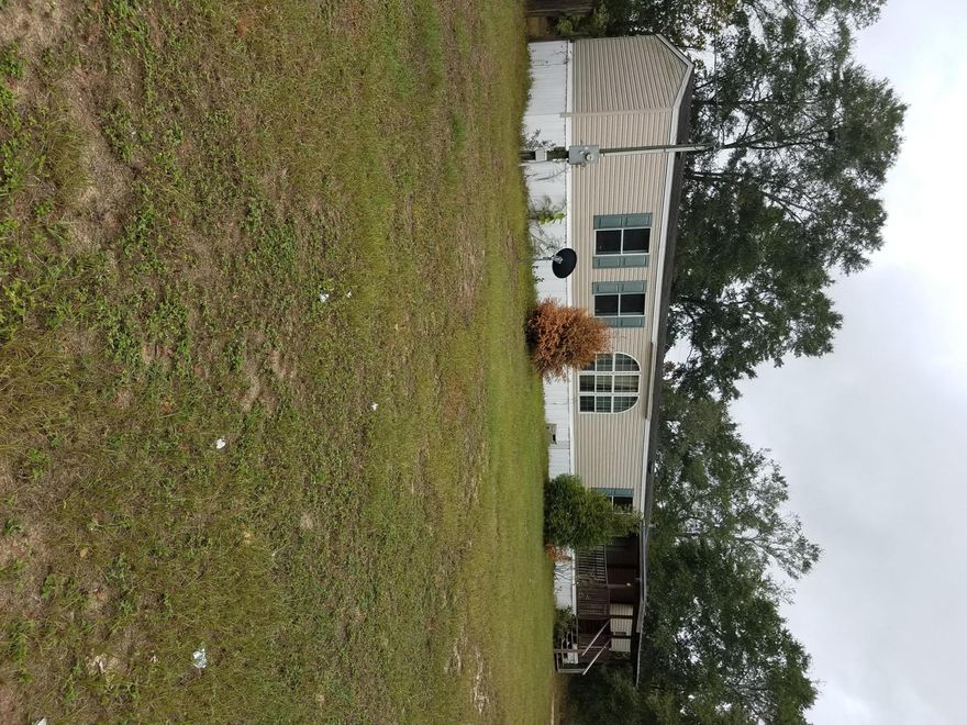 Nice mobile home on 2 lots. Close to Highway 90. 3 bedrooms and 2 baths. Walk in closet in master. Garden tub in master with large walk in shower. Refrigerator and stove convey. Needs a little TLC but move in ready. Large fenced in back yard. Large covered porch at front door.
