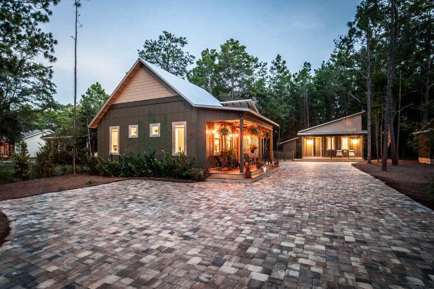 MOTIVATED SELLER! Custom designed Home with Guest Cottage in Historic Pt Washington, comprised of the highest grade construction and finishes! Main house features 2 Bedrooms & 2 Baths, open living area, and kitchen with granite countertops and high end GE Appliances. Bathrooms are lined throughout with Travertine. Main house also boasts a tank-less water heater, as well as energy efficient central heat and air, high, peaked ceilings with modern industrial air vents and high end laminate flooring. Exterior front and back porches were made from beautiful composite TREX decking and were built with entertainment in mind. Maintenance free lawn around property with Cass Stone Driveway. Corrugated aluminum metal roof to finish out the contemporary look of the home.