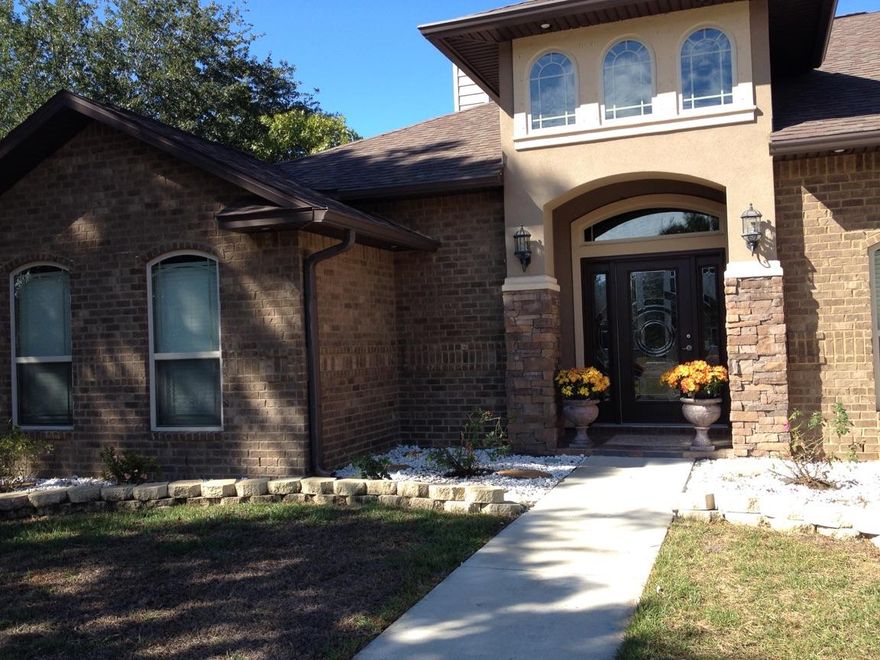 This exquisite 2012 picturesque, stucco and stone accented brick home with a well-lit columned-entry is both awe-inspiring and inviting. Some of the impressive features are: 3 or according to use 4 bedrooms, 3 full baths, a modern yet quaint kitchen with granite countertops, stainless steel appliances and drop-down lighting. Arched entries to common areas that also feature dramatic ceilings: either octagonal, boxed and/or high ceilings. Plant ledges, 5 x 8 bar, and French doors to the lanai. Ceramic tile/granite in wet areas, bull-nosed corners and fireplace in the great room. Home also features large closets, upgraded lighting and plumbing, media connections . . .The master suite features a large bathroom with dual sinks inset within granite countertops. A separate tub and large walk-in shower in a luxurious setting. The exterior features: a covered lanai, sprinkler system, flood lighting, HVAC system, low-E windows, fenced yard and more . . . You must see to appreciate the many, many amenities.