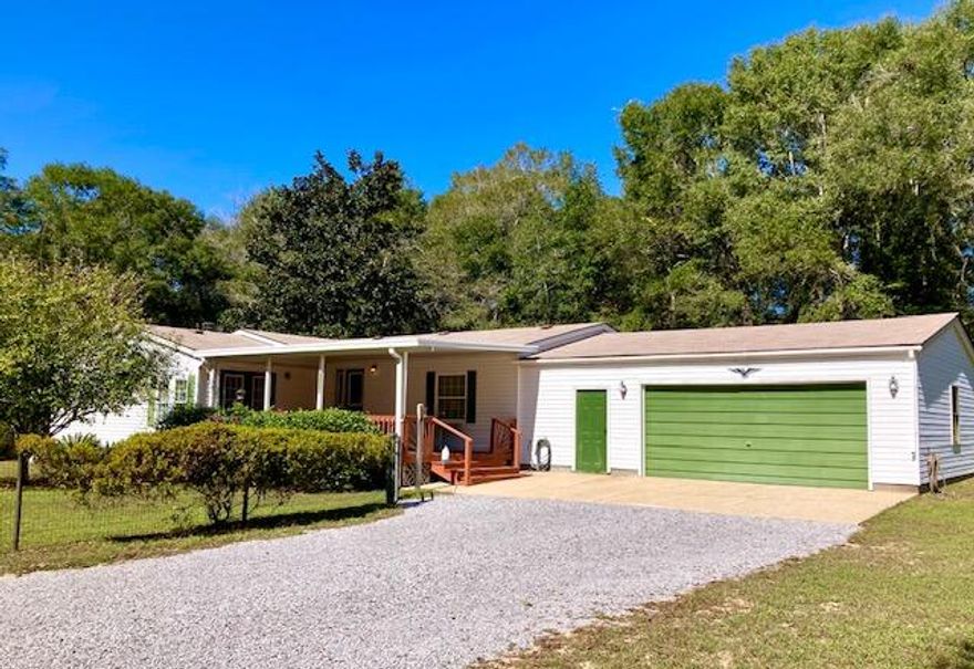 VERY NICE WATERVIEW HOME CLOSE TO TOWN!  You won't believe this immaculate triple-wide home situated on a double lot facing Lake Juniper. This 3BR 2BA one-owner home has been lovingly cared for and upgraded. Open Kitchen features oak cabinets, custom tile backsplash, stainless appliances & breakfast room. Dining room has newer laminate flooring and a glass divider overlooking the cozy Den with stone fireplace & electric log insert. Split Floor plan with two bedrooms & a bath at one end of the house and a primary Bedroom on the other end, just past the HUGE Living Room. The partially fenced double lot has a nice lake view from the front porch, plus room for a shop or garden. The large garage offers flexibility for all your hobbies. Located just 30 miles from our beautiful white sand beaches