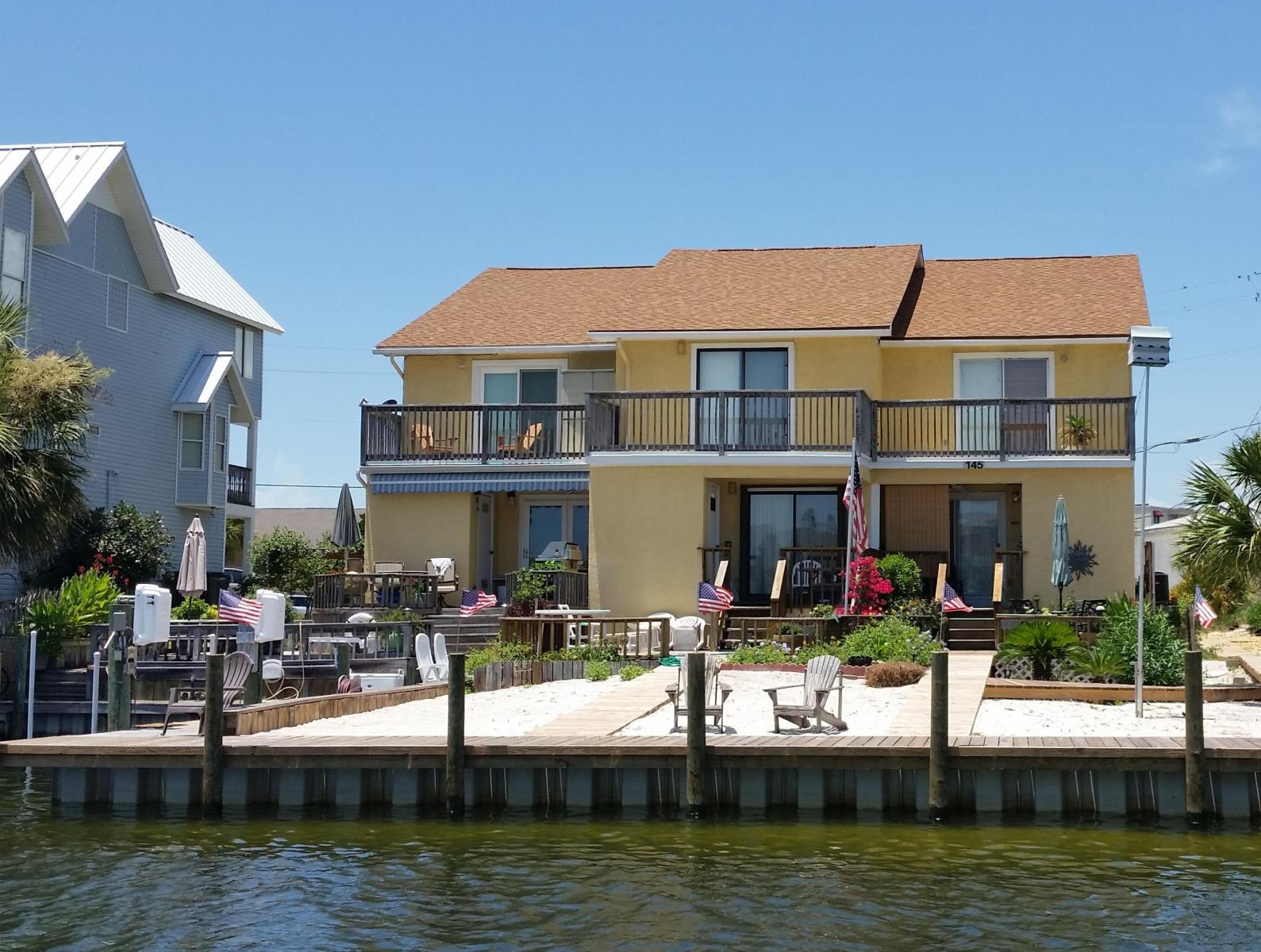 Escape to a lifestyle in paradise! Come view this spacious two bedroom waterfront property on the prestigious Holiday Isle! This property would be a wonderful investment for vacation rental or as a second home. This canal front townhome comes with a private 35 ft. boat slip with lift and HOA deeded beach access. The dcor is tastefully updated and all of the furnishings are included. **Property sold AS IS** **Pictures coming soon**