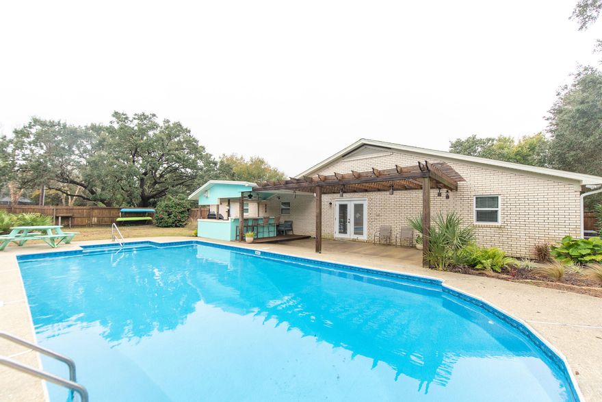 WELCOME HOME. This Updated brick home is in a popular and quiet Gulf Breeze neighborhood. Just steps to the water but not in a flood zone. Zoned for all 3 Gulf Breeze Schools this area is highly desired. At 2,412 sq ft this home sits on nearly a half acre corner lot. Inside you will find new tile floors, an open floor plan with a living room and a cozy den with a custom stone fireplace. The kitchen features solid surface counter tops, stainless steel appliances, upgraded gas stove, and an abundance of cabinet storage. The large master bedroom has three closets, and the master bathroom has a large tiled rain shower with a double vanity. The two guest bedrooms share a beautiful bathroom with a double vanity and jetted tub. The backyard features an inground pool with a new liner, and an outdo WELCOME HOME. This Updated brick home is in a popular and quiet Gulf Breeze neighborhood. Just steps to the water but not in a flood zone. Zoned for all 3 Gulf Breeze Schools this area is highly desired. At 2,412 sq ft this home sits on nearly a half acre corner lot. Inside you will find new tile floors, an open floor plan with a living room and a cozy den with a custom stone fireplace. The kitchen features solid surface counter tops, stainless steel appliances, upgraded gas stove, and an abundance of cabinet storage. The large master bedroom has three closets, and the master bathroom has a large tiled rain shower with a double vanity. The two guest bedrooms share a beautiful bathroom with a double vanity and jetted tub. The backyard features an inground pool with a new liner, and an outdoor kitchen complete with tile countertops and stainless steel gas grill. This house is meant for entertaining. The water heater has been upgraded to a tankless gas heater. There is a half bath next to the kitchen and laundry that makes for a great pool bathroom.  Need an extra bedroom, office, or gym? There is a bonus room that would be perfect. Incredible price and huge lot, you can't beat this deal directly behind Grand Pointe! a few extras: sprinkler system that is on a well, 2 Car garage with finished flooring, new windows, new gutters, new garage doors, new egress doors, Rebuild NWFL residential wind retrofit, new septic lines and so much more. There is a list of updates that you can download for more info.Call The Hurd Team today for a tour of this Gulf Breeze Beauty