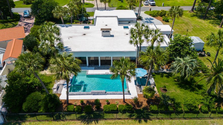 Simply stunning and spacious, custom home situated on a double lot overlooking the golf course. This impressive property boasts 200' frontage on the 16th fairway of the Championship course at Legacy Golf Club in popular Colony Club subdivision. From the minute you arrive, this lovely home will enchant you with it's unique charm and peaceful Zen like atmosphere. Custom built for his personal home by local architect Jim Chapman, this stunning house has many unique features and has been extensively and meticulously upgraded by it's current owners. White concrete, stucco and hardieboard exterior, steel frame and commercial grade flat roof with TPO (new in 2019) contribute to the durability of this home's quality construction and contemporary style. As you approach the front entrance, there's a beautiful Koi pond, extending the length of the front pathway, hinting at the sense of serenity that awaits once you enter this beautiful home. Step inside and you are greeted with elegant marble flooring and a huge sunken living room, featuring a double sided wood burning fireplace, built-ins and desk area. The full wall of floor to ceiling windows and sliding glass doors bathe this great room in natural light, seeming to let the outside in, allowing expansive and impressive views of the salt water pool and the golf course beyond. Wow!! 
The spacious, modern kitchen, features a beautiful bay garden window, color changing smart lighting system, sleek gray soft-close cabinets, quartz countertops, a beautiful black marble center island and breakfast bar. Stainless steel appliances, include an induction cooktop and GE Profile Advantium oven and microwave, a chef's delight, and commercial size refrigerator. Just off the kitchen is a very spacious laundry room with plenty of additional cabinet space, quartz countertops, stainless steel refrigerator, sink and double pantry. 
The master suite is a delightful retreat, with golf course view and access to the pool and patio. Adorned with custom lighting, custom blinds and custom drapes, wool carpet, floor to ceiling windows, the bedroom also boasts a beautiful private courtyard, with access to and from both the bedroom and bathroom. The bathroom features a free standing tub, separate tiled open shower, double vanities, double custom closets and the luxury of a heated bathroom floor! There's a sauna and steam shower just off the main bathroom. Two additional bedrooms, one with it's own private tiled courtyard, the other with a secluded outdoor sitting area overlooking the golf course with access to the pool and patio. The 16 x 32' salt water pool, new in 2020, with waterfall ledge, custom lighting and hot tub, provides the perfect place to relax, unwind and enjoy the peaceful surroundings and splendid golf course views. Additional rooms include two guest bathrooms, an office/study currently used as a music studio, and a bonus room currently used as a wine room. The home is energy star equipped with dual HVAC systems, a mini-split and three hot water heaters. The oversize double garage, circular driveway, plus additional concrete driveway, allow for ample parking of multiple vehicles, boat or RV. The extra land provided by the double lot affords the opportunity for numerous possible future uses, such as mother-in-law/guest house, or pickleball court. There is NO HOA. This house is close to Gayle's Trails, Pier Park for shopping and dining, a short distance to many local attractions and close to several beach accesses to enjoy all our beautiful local beaches have to offer. 
Come experience the splendor of this magnificent and unique custom golf course home, and see for yourself the many details that make up it's delightful charm and everything it offers for a relaxed, unparalleled and exquisite golf and beach lifestyle!
All information is deemed reliable but all measurements and square footage should be verified if importa