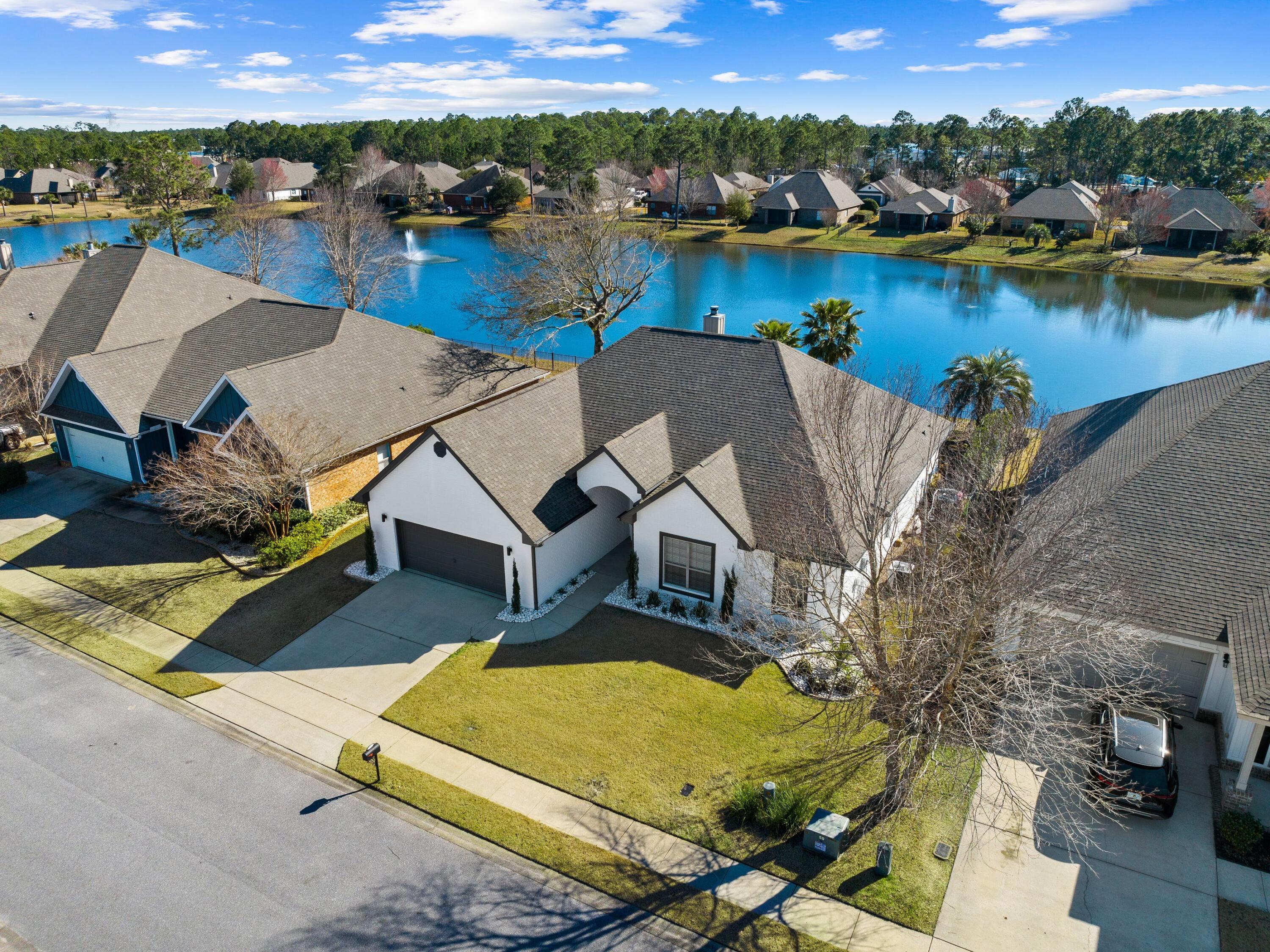 Close to Blue Mountain Beach, this amazing updated home is brimming with design features and is move-in ready. Enviably located in a peaceful neighborhood, this desirable residence overlooks a lake and wildlife. The private backyard includes a heated and cooled pool, lush landscaping and a fountain. It's ideal as a full-time residence for first-time buyers, retirees or those looking to enjoy a coastal lifestyle. Laid out all on one level, the home has four beds, two full baths, a cloakroom and an attached two-car garage. Bonus features worth mentioning include a built-in desk area in the fourth bedroom and a spacious master suite with a sitting area, a large walk-in closet and a sliding barn door to the master bath.