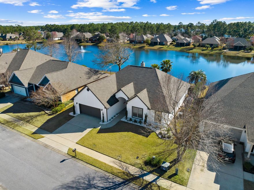 Close to Blue Mountain Beach, this amazing updated home is brimming with design features and is move-in ready. Enviably located in a peaceful neighborhood, this desirable residence overlooks a lake and wildlife. The private backyard includes a heated and cooled pool, lush landscaping and a fountain. It's ideal as a full-time residence for first-time buyers, retirees or those looking to enjoy a coastal lifestyle. Laid out all on one level, the home has four beds, two full baths, a cloakroom and an attached two-car garage. Bonus features worth mentioning include a  built-in desk area in the fourth bedroom and a spacious master suite with a sitting area, a large walk-in closet and a sliding barn door to the master bath.  Hardwood flooring seamlessly connects the well-lit dining and living areas. A cozy fireplace adds a focal point. Soaring vaulted ceilings are highlighted with updated lighting and deep crown molding. An archway leads into a bonus space suitable for use as an office, media or game room. The updated kitchen has many natural elements including a white brick-faced peninsula bar and beautiful quartz countertops. Keen cooks will find a full array of stainless steel appliances at their fingertips along with ample storage. Outdoor living is a delight with a covered patio where you can relax and enjoy the peaceful lake views. The fenced backyard is ideal for keeping kids and pets secure as well as providing privacy when entertaining. The covered lanai looks out across the paved terrace to the pool with tanning shelf and the lake beyond. Close to many restaurants, shops and amenities, this pristine home is also within easy reach of beautiful beaches, hiking trails and outdoor recreation at Topsail Hill Preserve and Point Washington State Forest.