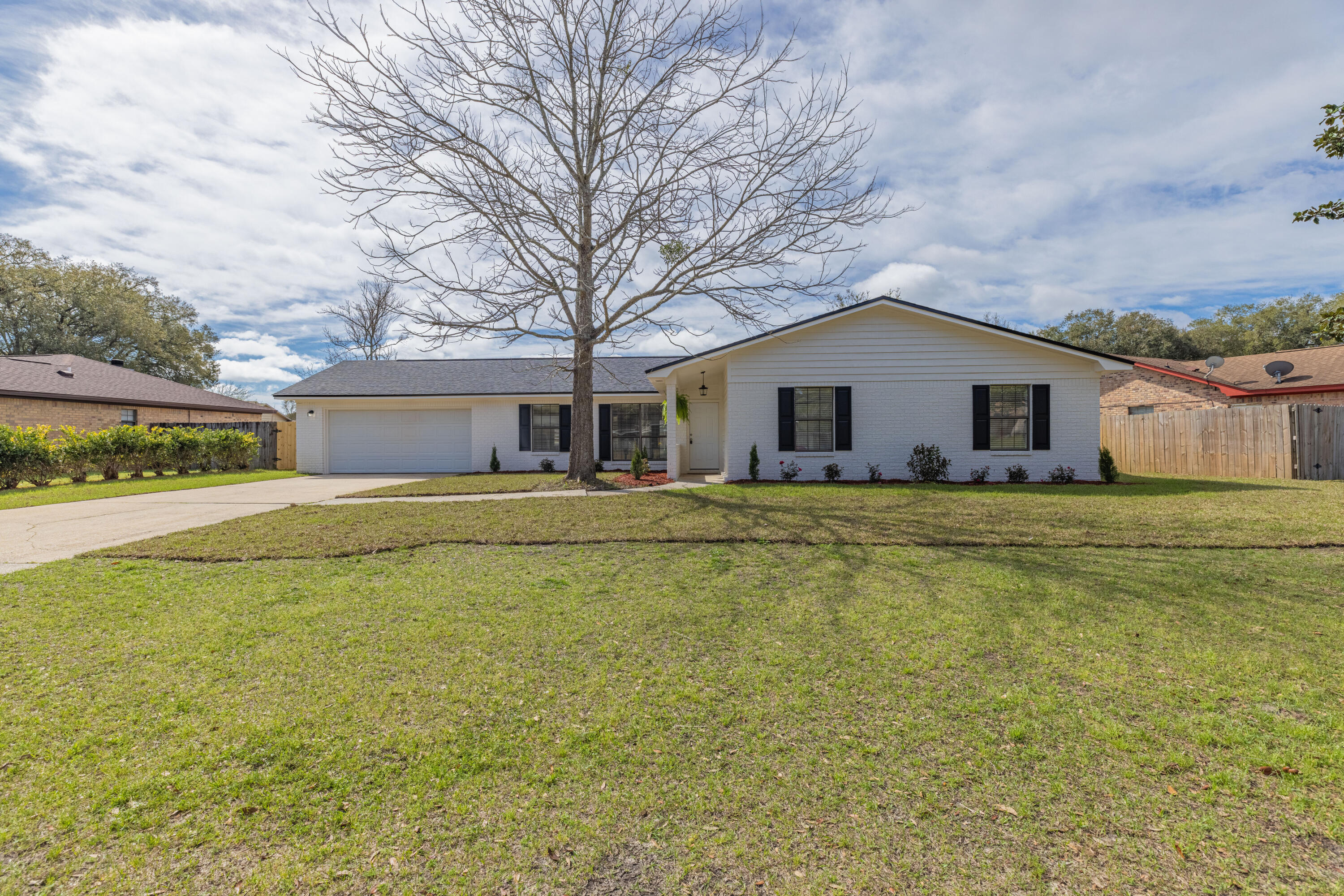 Beautifully remodeled 4 bedroom home ready for its new owner! Stunning curb appeal greets you Gorgeous modern neutral floors and an open living space greet you and your eye will be drawn to the shiplap accent wall with electric fireplace. All new kitchen with granite countertops, stainless steel appliances, large island with bar seating and direct access to the dining room. Master bedroom has an en suite, walk in closet and french doors leading to the back yard. Three additional bedrooms all have new paint, floors & fixtures and the guest bathroom has been fully updated too giving it a luxurious yet functional feel. Tons of additional closet and storage space! Large fenced in back yard will be the perfect place to make memories and enjoy our beautiful Florida weather! New roof, new water