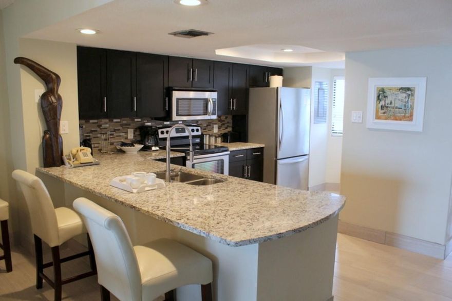 Unit redone in 12/2014 with many upgrades. Check out the beautiful granite countertops in the pictures. Both bathrooms have granite countertops and new cabinetry. The kitchen has been upgraded with new contemporarycabinetry and new stainless appliances, plus fixtures. Full size washer and dryer is a plus to have with a family. There is tile throughout the unit. Flat screen TV's in living area, and both bedrooms. The dining area can accommodate up to 9 people. Also, 4 barstools at the Breakfast Bar. The view from this level is outstanding as you can see the pools and the beach. There is a children's pool and a heated spa. A pleasant surprise at the pools is a Tiki Bar & Grill. Enjoy approx. 400' of beachfront. Two levels of covered parking, playground area for children, fitness room.