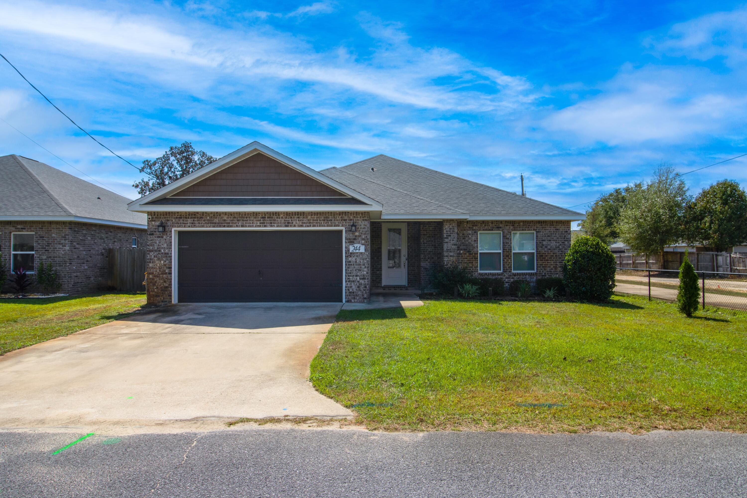 New to the market, please consider this turnkey 3-bed/2-bath home in Mary Esther, Florida, offering 1,936 SF of thoughtfully designed living space! Built in 2019, this open-concept features a spacious living room with tray ceilings, tile flooring in all main areas, and plush carpet in the bedrooms. The kitchen includes stainless steel appliances, wood cabinetry, granite countertops with a breakfast bar, and opens into the dining and living spaces. The primary suite offers his-and-hers closets, double vanity, tub, separate stand-up shower, and private water closet to buyers. The formally open back porch has been enclosed to create a bright Florida room with a mini-split unit for year-round comfort. Additional highlights include a large fenced backyard, two-car garage, washer and dryer well with sprinkler system, and a fully finished interior with designer cabinetry, crown molding. This home combines quality craftsmanship and modern finishes in a prime Mary Esther location, approximately 3.8 miles from Hurburt Field, 15.8 miles from Eglin AFB, and 11.3 miles to Okaloosa Island Beaches!