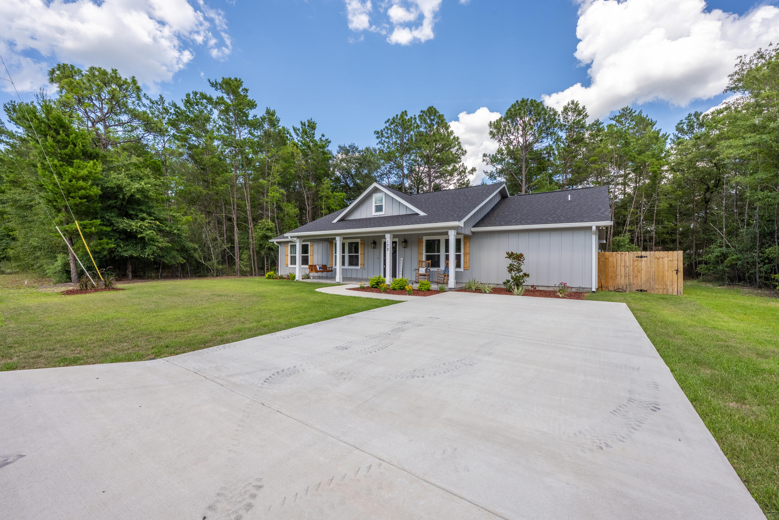 Welcome to your beautiful NEW home! Single story, split bedroom floor plan--check! Massive master bathroom with custom tiled shower, separate throne room & a closet dreams are made of--check! Country setting (with a couple adorable cows across the street)--check! This home checks all the boxes. The family chef will be pleased with the large kitchen, featuring a gas stove, white soft-close cabinets topped with classic quartz and a fancy faucet (it lights up!), big pantry to store your stand mixer and air fryer, etc. The island IS an island, with over 9 ft of bar seating, herringbone tile work, and a plethora of counter space. The kitchen opens to the dining and living room, with access to the back porch, perfect for entertaining guests and hosting holiday meals. Soaring ceilings make the home live even larger! Enjoy a little bit of country with the shiplap accent wall, and the convenience of the modern gas fireplace. The laundry room has cabinets with butcher-block countertops and a perfect spot for a deep freezer. The water heater is energy-efficient: tankless gas.
Character and fine craftsmanship abound! The porcelain-tile work is incredible, seamless transitions from living space to bathrooms--no carpet for ease of cleaning and reduce allergens. Classic craftsman style wood trim dresses each window, board and batten exterior is beautiful and made to last with concrete fiber board. Barn door detail at the first room (office), an apron sink in the kitchen and 3 panel white doors add rustic charm. Big windows let in lots of natural light, and LED lights are easy on the power bill. You'll enjoy morning coffee on your front porch swing (245 sq ft front porch) and listen to the crickets in the evening with a cold drink on your covered back porch (200 sq ft). The back yard has lots of trees, and the septic tank was placed in the front, in case you'd like to put in a pool. This new build features several upgrades that most don't: gutters, sprinkler system and a privacy fence! This home has great design, quality craftsmanship, and is conveniently located in the beautiful Mossy Head area, just about 3 miles to the I-10 access point at Hwy 285. Only about 14 miles to growing historic downtown DeFuniak Springs, famous for its perfectly round spring-fed lake; (did you know Walton County has more than 40 lakes?!) about 31 miles to the sugar white sandy beaches of Destin! Peaceful living is yours to enjoy with recreation and nearby amenities. Make this one your Home-Sweet-Home!
All information believed to be accurate, buyer to verify all facts deemed important.