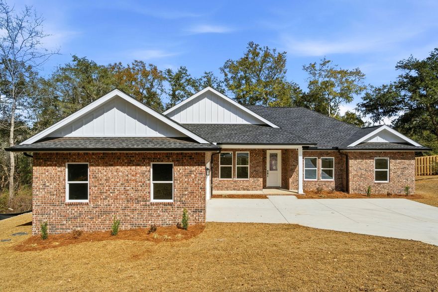 Brand new construction and move-in ready, this exceptional 5-bedroom, 2.5-bath home is located in the gated community of Habersham in Pace, Florida. This thoughtfully designed residence offers an open-concept layout ideal for everyday living and entertaining. The spacious living room features tray ceilings and flows seamlessly into the well-appointed kitchen, complete with quartz countertops, all-wood cabinetry, soft-close dovetail drawers and doors, a large walk-in pantry, and an expansive dining area. LifeProof luxury vinyl plank flooring runs throughout the home, complemented by custom trim work, a modern lighting package, and durable, superior-grade interior paint. The primary suite serves as a private retreat with tray ceilings, a custom walk-in shower with glass enclosure, 6-foot garden tub, private water closet, custom mirrors, and direct access to the covered back porch.
Exterior features include a 100% brick exterior, architectural dimensional shingles, Hardie cementitious soffits, triple-coated high-grade exterior paint, stained tongue-and-groove porch ceilings, and an 8-foot entry door with half-light glass. Additional highlights include a finished oversized courtyard side-entry garage, custom oversized driveway, brick mailbox, full-yard sod, professional landscaping with irrigation system, gutters with French drain system, underground utilities, and connection to public sewer. Situated on one of the largest lots in the community on a .67 acre lot, the property backs to a serene wooded buffer, spring fed creek, and pond, offering exceptional privacy and peaceful views. Schedule your private showing today and experience this move-in ready home for yourself.