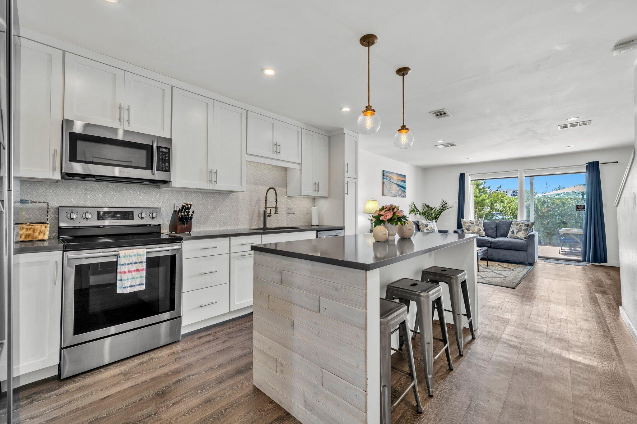 Steps from the Gulf, this Remodeled 2BD/2BA Townhome on Holiday Isle is the perfect Beachside Getaway or Investment rental! Enjoy an Open-Concept layout with Quartz countertops, white cabinetry, LVP flooring, and a Spacious island that's ideal for entertaining. Walk out into a fenced, partially-covered outdoor patio perfect for sunning or having a small BBQ. Upstairs, the Primary Suite features a Private Balcony with peek-a-boo Harbor and Gulf views! Additionally, you'll find a cozy bunk room and a shared full bathroom with a large vanity and tub/shower combo. Additional perks include an outdoor shower, storage shed, in-unit laundry room, dedicated workspace, new HVAC (2022), and smart thermostat. Short drive or walk to Destin Harbor, shopping, dining, and water activities!