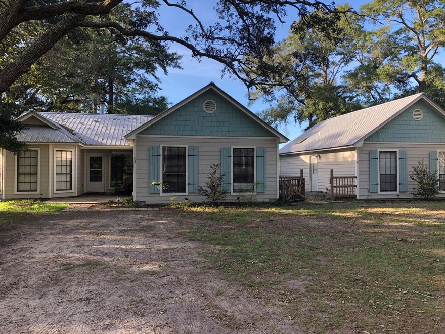 No HOA! Cutest cottage style home in Freeport with 4 bedrooms and 2 full baths, family room with wood burning stone fireplace, tongue and groove ceiling with beams, wood look flooring through out. 2 bathrooms with tile and showers. Granite counter tops, oversize laundry room and mud room entry thru courtyard. Separate guest house. The guest house includes master with stack laundry hook up, full size bath with walk in shower and kitchen family room combo. This home is on 1 +/- acre surrounded by mature trees and has a structure that is heated and cooled that can be used as storage or workshop. Close to bases, beaches and C6 area. GREAT investor potentia!!! Currently a tenant rents the guest house for $900 a month. Can stay or leave depending on buyer wishes.