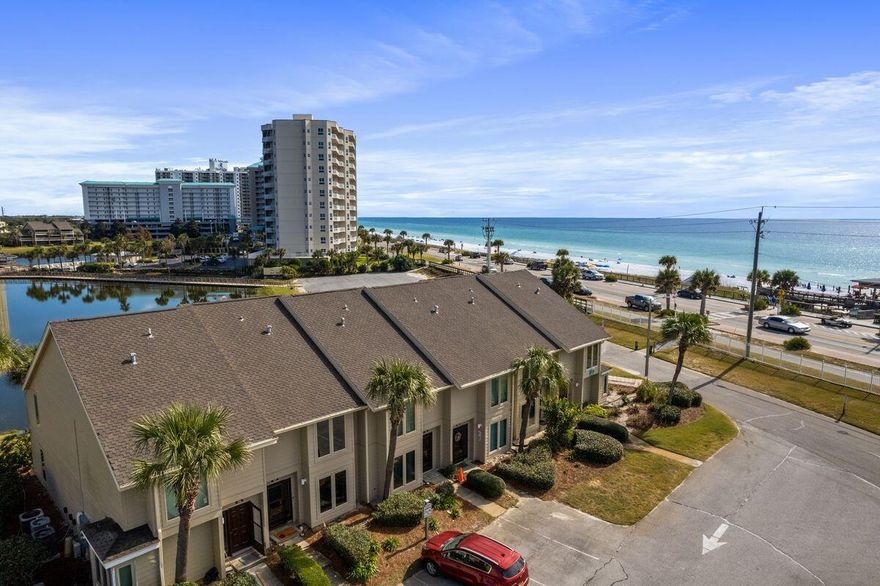 It's rare to find a condo with both gulf and lake views, but this primely located end unit at Seascape has it all. It's one of the closest condos to the beautiful sandy beach and a short hop from the community pool. The acclaimed Whale's Tail Beach Bar and Grill is right across the street for breakfast, lunch and dinner. Step inside the front door and check out the first of two living rooms. This could easily be converted to a third bedroom to increase rental income and add desirability. The white wainscoted hallway includes a half bathroom. The hallway flows into a neat dining area and modern open kitchen with tile flooring. Granite countertops, stainless appliances and a breakfast bar feature in the well-planned space. Stunning views draw you into the attractive main living space. It's