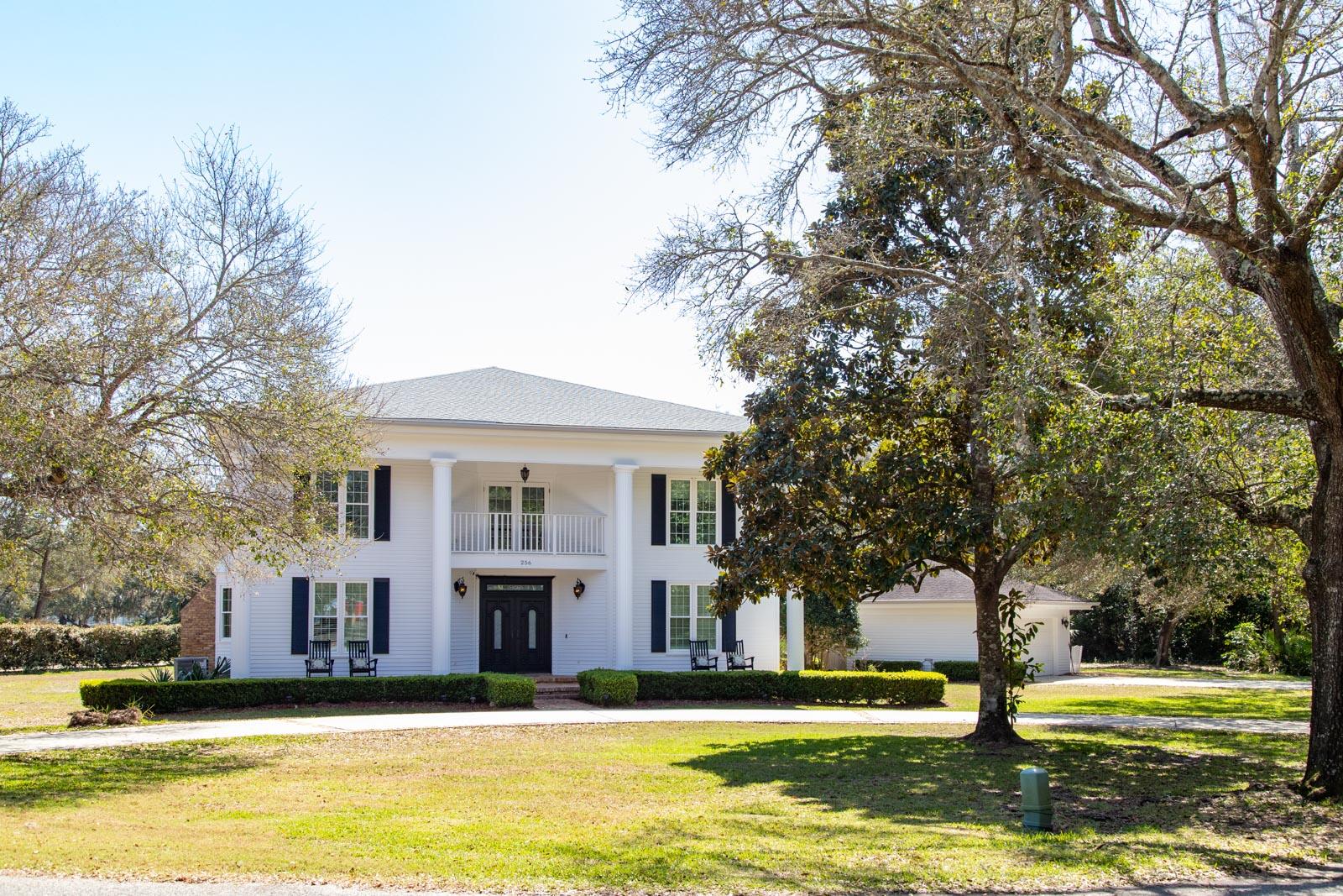 A rare gem situated on almost an acre of land on a no-thru street in the heart of Fort Walton Beach. This Southern charmer greets you with grand entrance; white columns set off the inviting front porch, and a balcony overlooking Cinco Bayou.  22' ceiling in the living room with a marble surround, gas fireplace, stacked windows and a custom-built wet bar. Kitchen is complete with Meile cooktop and oven/micro combo, a huge center island and tons of custom cabinets for storage.  Also, the kitchen and breakfast nook have the perfect view of the backyard, & pool. The conveniently placed grilling station outside just off the kitchen.