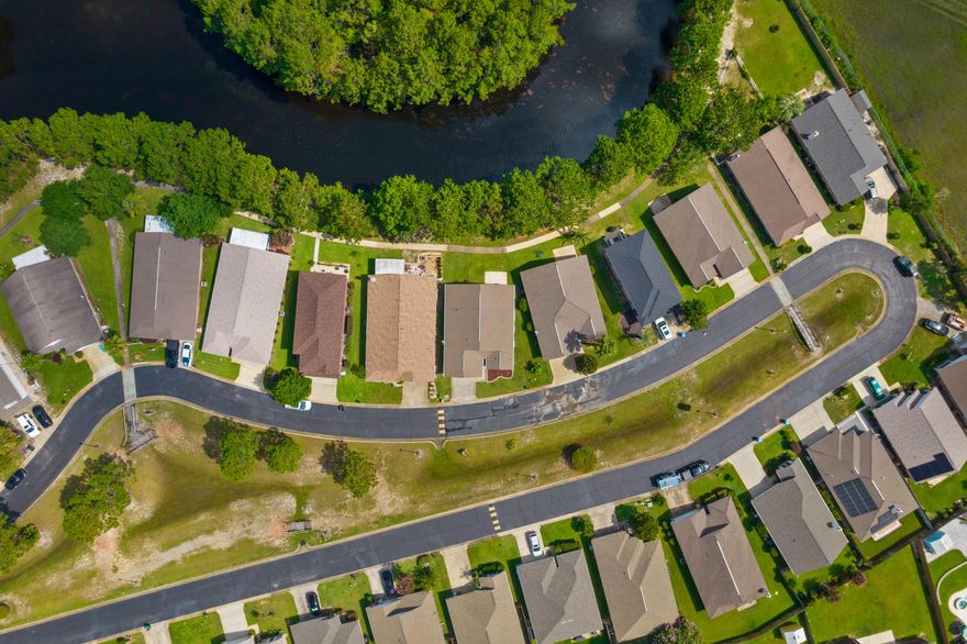 Welcome to Parkers Landing, the gated subdivision that has lakes, a community pool and the closest commute into town. This home is located in East Navarre which is desirable especially if you are driving to Hurlburt Field AFB often. You will go North on Whispering Pines and follow the road back about a mile until you enter the gated entryway. Feel the security as soon as you pull. When you enter the home, you will notice the well kept curb appeal and the Lake views in the backyard with sidewalks and mature trees. Walk your pets or ride your bike throughout the community, and then go for a dip in the pool within walking distance of your home. This four bedroom, two bath home has an open layout for the growing family, or use the fourth room as an office.  CLICK MORE.......... The kitchen has crisp white cabinets and appliances. The stainless steel refrigerator will convey with the home as well. The thermostat has been updated too. There is zero carpet in this home for a cleaner feel. Don't worry about soiled carpet and padding from other homes when you can just move right in with throw rugs and your belongings! Tons of natural lighting come through with all the windows and back door to the Lake. This home is now vacant, cleaned and emptied for easy showings so you can move in quickly!!