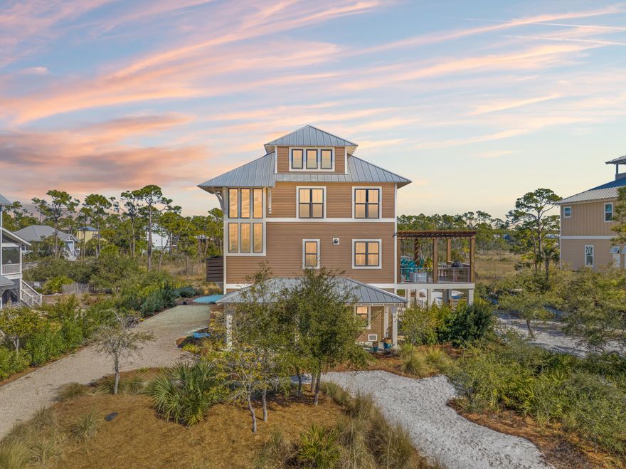 Welcome to 510 WindMark Way, a coastal luxurious 4-bed, 4-bath custom home built in 2021, offering 3,563 sqft of climate-controlled living space. Designed for comfort and elegance, it features high-end finishes, custom panel walls, and ceramic, stone, and wood flooring. The gourmet kitchen includes BlueStar appliances and stunning St. Joseph Bay views. The master suite offers a spa-inspired ensuite and direct patio access. Outdoors, enjoy 1,480 sqft of covered porches, a balcony kitchen with pergola and outdoor kitchen, and the best panoramic views. Residents have access to exclusive amenities, including 3 pools, a private clubhouse, bike paths, and more. Built for efficiency and security with hurricane-rated windows and more.