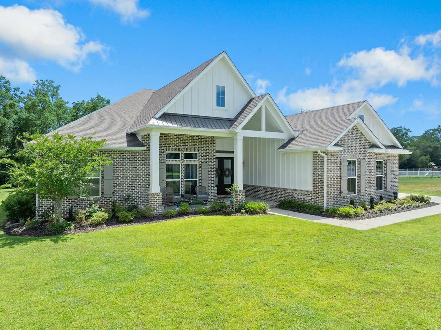 Welcome to your dream home, beautifully landscaped and built in 2021, offering the perfect blend of space and luxury. This 5-bedroom, 3-bath residence, complete with a 3-car garage, is located in the highly sought-after gated community of The Moors Golf and Racquet Club. Enjoy the convenience of being just minutes from I-10, ensuring an easy commute to any local destination. As you step onto the charming covered front porch with its inlaid brick floor, you're welcomed into a spacious entryway. Inside, the home features exquisite Nantucket Oak LVP flooring, designer lighting, handpicked tile, and detailed wood trim. Soaring ceilings of 10, 11, and 12 feet enhance the open and airy feel of the space. Double French doors from the expansive living area lead to a generous patio, perfect for outdoor entertaining. The chef's kitchen is a highlight, featuring a 10-foot center island, quartz countertops, custom cabinetry, and top-of-the-line premium GE Caf?? appliances. The thoughtfully designed triple split floor plan offers privacy, with a secluded owner's suite that includes a walk-in shower, freestanding tub, dual vanities, and a spacious walk-in closet. Extras include custom window treatments in the living room, primary bedroom and primary bathroom. The washer and dryer will convey with purchase. The three-car side entry garage provides convenient access, and the large attic above offers ample storage with spray foam insulation. The home is equipped with hurricane shutters for additional peace of mind. Every detail in this home has been carefully considered to provide comfort and style. This exceptional residence is ready for you to make it your own. Discover the beauty of this home schedule your showing today!