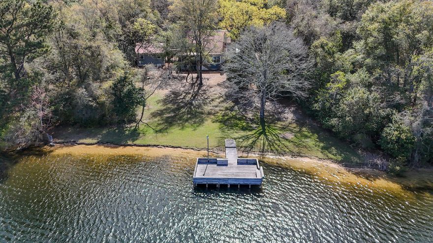 Nestled on 1.3 acres with almost 200 feet of  lake frontage, this impeccably maintained 4 BR 2.5 BA home on Spring Lake is not a listing you find everyday. Stepping into the home, you are greeted with incredible lake views from the open concept living area and kitchen, as well as exceptional views from the main floor master bedroom. The Master Bedroom features a large bath with walk in shower and separate jetted tub  Also located on the main floor is a walk in pantry/laundry room, a formal dining room, a half bath and a screened in sun room for enjoying gorgeous sunset views! Upstairs you will find 3 additional bedrooms and a full bath.  SEE MORE This home has so many extra features such as a certified storm shelter in the master bedroom, a Generac whole home generator, an on demand tankless water heater, RV hookup, an oversized two car garage with attic connected to the home by a breezeway, a whole home security system and the neighborhood even has a FLOCK camera with 24/7 monitoring!
For reduced insurance and peace of mind, the metal roof is less than 3 years old. The septic system was replaced in 2025. 
Travel from the back deck down the very gently sloped yard to the showstopper of this property, gorgeous Spring Lake! Spring Lake Estates is a small community of homeowners who enjoy a quiet, peaceful way of life in the lakeside community built around a 150-acre private lake. Amenities include a large dock & boat launch area, pole barn & community gathering space, smaller common area dock for relaxation and two dedicated community access points. 