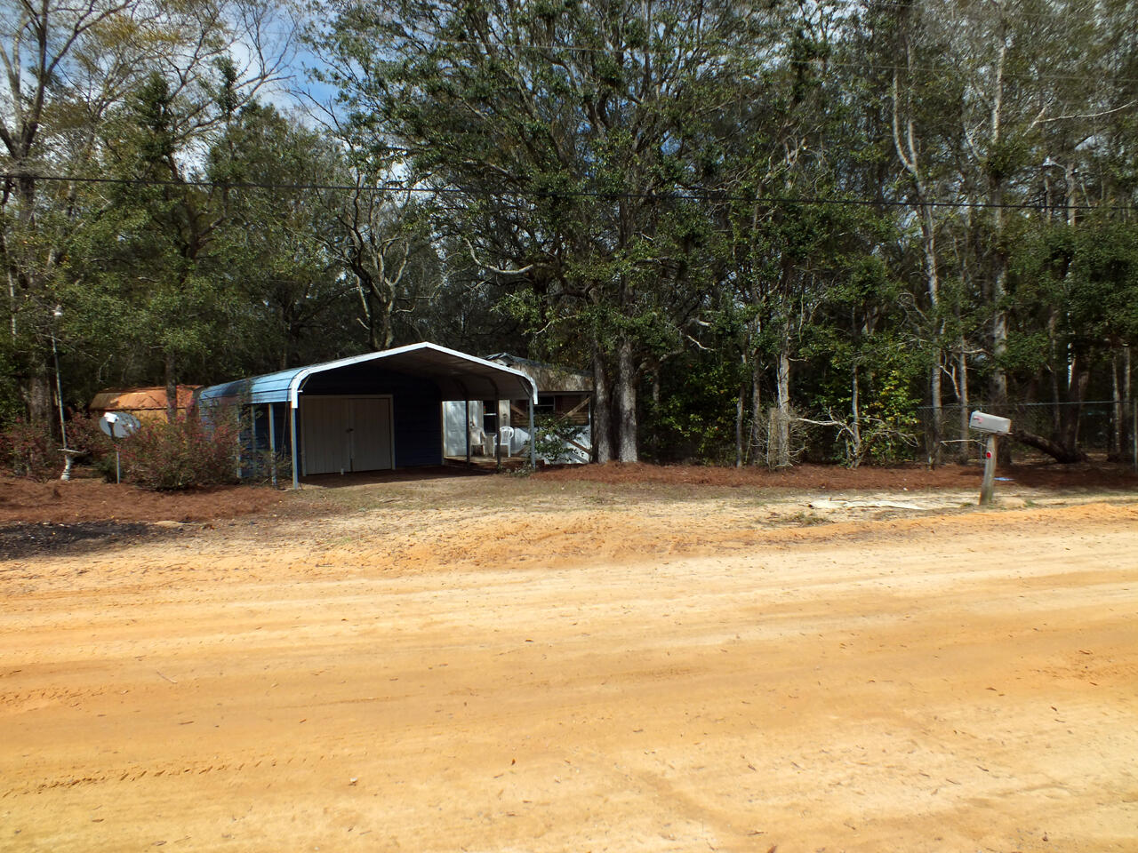 Property has a manufactured home, a carport/storage building and a metal out building on 1.3 acres, which are partially fenced. The manufactured home has not been lived in for several years, but could possibly be updated to make it habitable. The property has power, community water and a septic system and is located only several miles from the I-10 Mossy Head interchange. No value has been given to any of the structures.